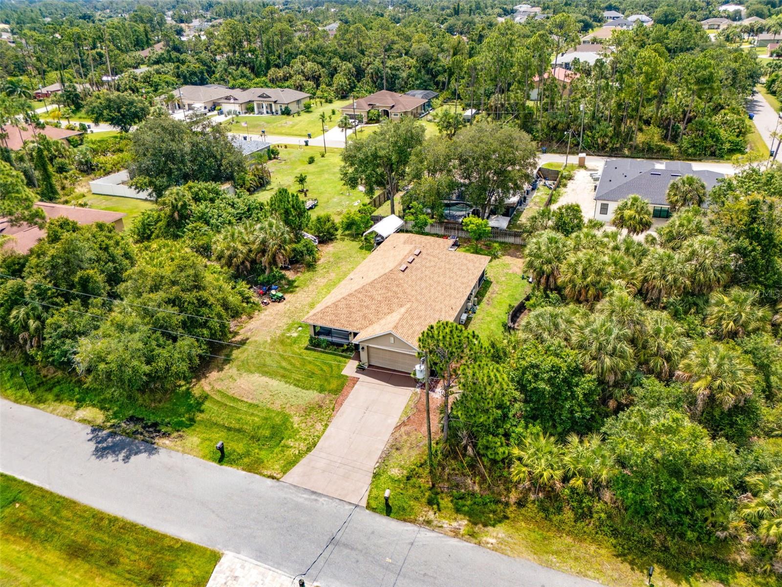 This RARE CUSTOM three-bedroom block home offers 2,700 square feet under roof, complete with a VERSATILE flex room and a SUBSTANTIAL, tiled, and screened GRAND PORCH & LANAII that provides a MASSIVE footprint with plenty of room to add an OVERSIZED pool. Situated in a NON FLOOD ZONE in the heart of bustling North Port, the property delivers ULTIMATE freedom and flexibility with no HOA fees, no CDD fees, and zero rental restrictions. The interior showcases the PINNACLE of CONTEMPORARY design, anchoring the space with SOARING 13-foot ceilings, LUXURY vinyl flooring throughout, and an EXPANSIVE slat wall that elevates the home's architectural aesthetics. At the heart of the home sits a GOURMET kitchen detailed with GORGEOUS countertops, MODERN cabinetry, a DESIGNER black hexagon tile backsplash, and a ROOMY pantry. The culinary space centers around an ENORMOUS island featuring an EYE-CATCHING wood slat accent with ELEGANT under-lighting, all BEAUTIFULLY illuminated by STUNNING artisan glass fixtures and ICONIC modern-crystal style pendants. For privacy and relaxation, the PRIMARY oasis serves as an EXQUISITE sanctuary. It features a HUGE walk-in closet, double vanities with MATCHING wood slat accents, and an ASTOUNDING wet-room equipped with a LARGE garden bath and a FULLY TILED shower. Thoughtful convenience and peace of mind are integrated throughout the home, which includes BESPOKE gold accents, a COPIOUS laundry room with ABUNDANT storage, TAILORED window drapery, and hurricane shutters. Perfectly located for the Florida outdoor lifestyle, this property sits just a short drive from the VIBRANT shopping and dining at Wellen Park, the HISTORIC Downtown Venice Avenue, and the DESIRABLE Warm Mineral Springs. You will also enjoy close proximity to the PRISTINE sands of Venice, Manasota, and Englewood beaches, making it an IDEAL paradise to experience the EXCLUSIVE best of the Florida lifestyle. Schedule your private showing today, and start enjoying your Florida paradise!
