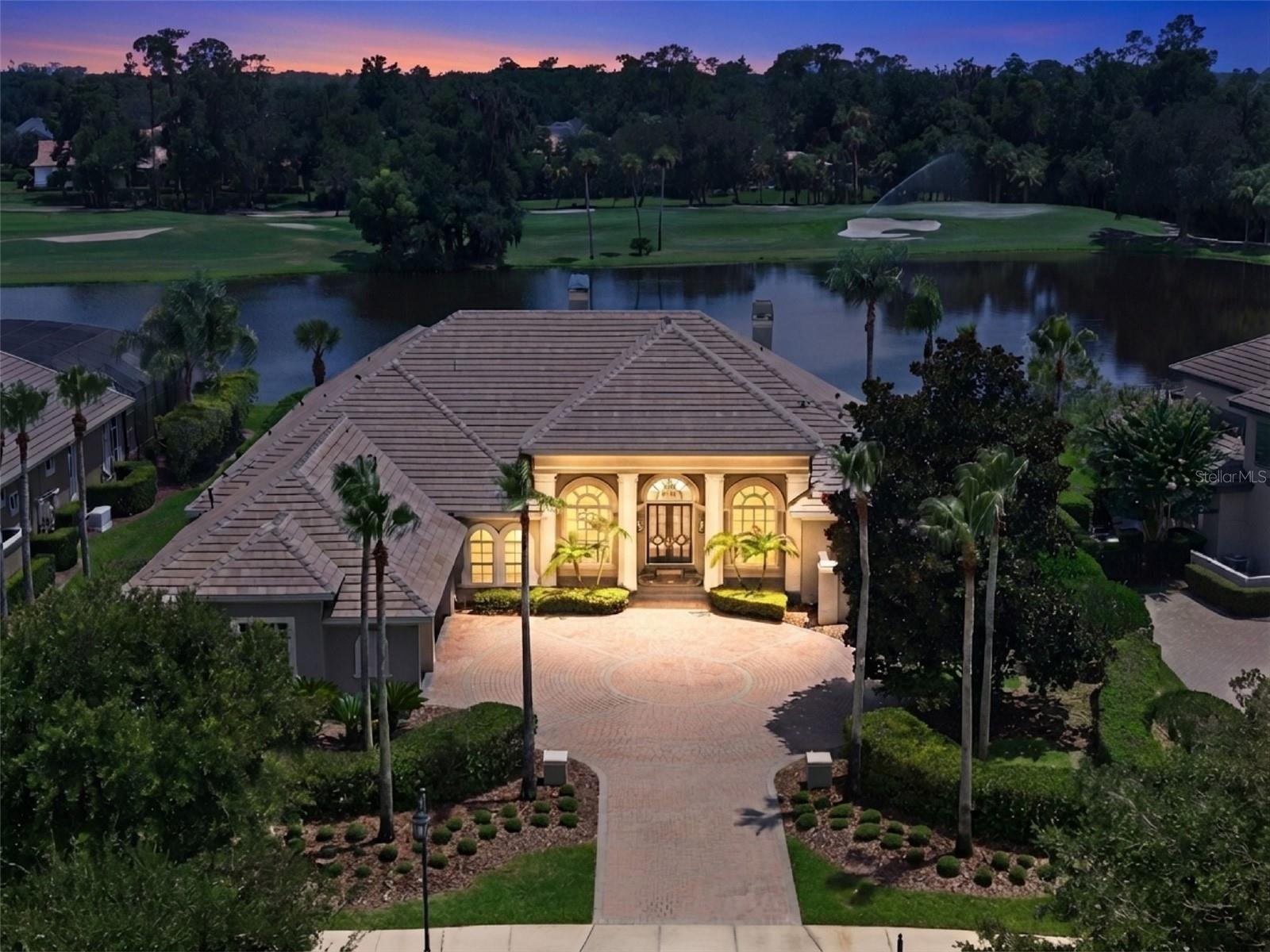 Experience luxury living in the highly sought-after Alaqua Lakes community in this exceptional Dave Brewer custom estate, situated on more than half an acre and offering over 5,000 square feet of thoughtfully designed living space. Perfectly positioned to capture breathtaking water and golf course views, this elegant residence combines quality architecture with comfortable everyday living. NEW ROOF - 2025. Designed with a desirable split floor plan, the home features 4 spacious bedrooms, 4 full bathrooms, and 2 half bathrooms. Soaring high ceilings create an open and airy atmosphere throughout, while multiple gathering spaces—including two bonus rooms—offer endless possibilities for a media room, home office, fitness studio, or playroom. The chef’s kitchen is equipped with a natural gas cooktop and seamlessly connects to the main living areas, making entertaining effortless. Enjoy cozy evenings by one of the home's gas fireplaces or step outside to the expansive screened lanai, where stunning views provide the perfect backdrop for outdoor dining and relaxation. Residents of Alaqua Lakes enjoy access to outstanding community amenities, including a resort-style pool and pavilion, five clay tennis courts, basketball and volleyball, a neighborhood park and playfield. Combining luxury, space, and an unparalleled lifestyle, this remarkable home presents a rare opportunity to own one of Central Florida's premier properties.
