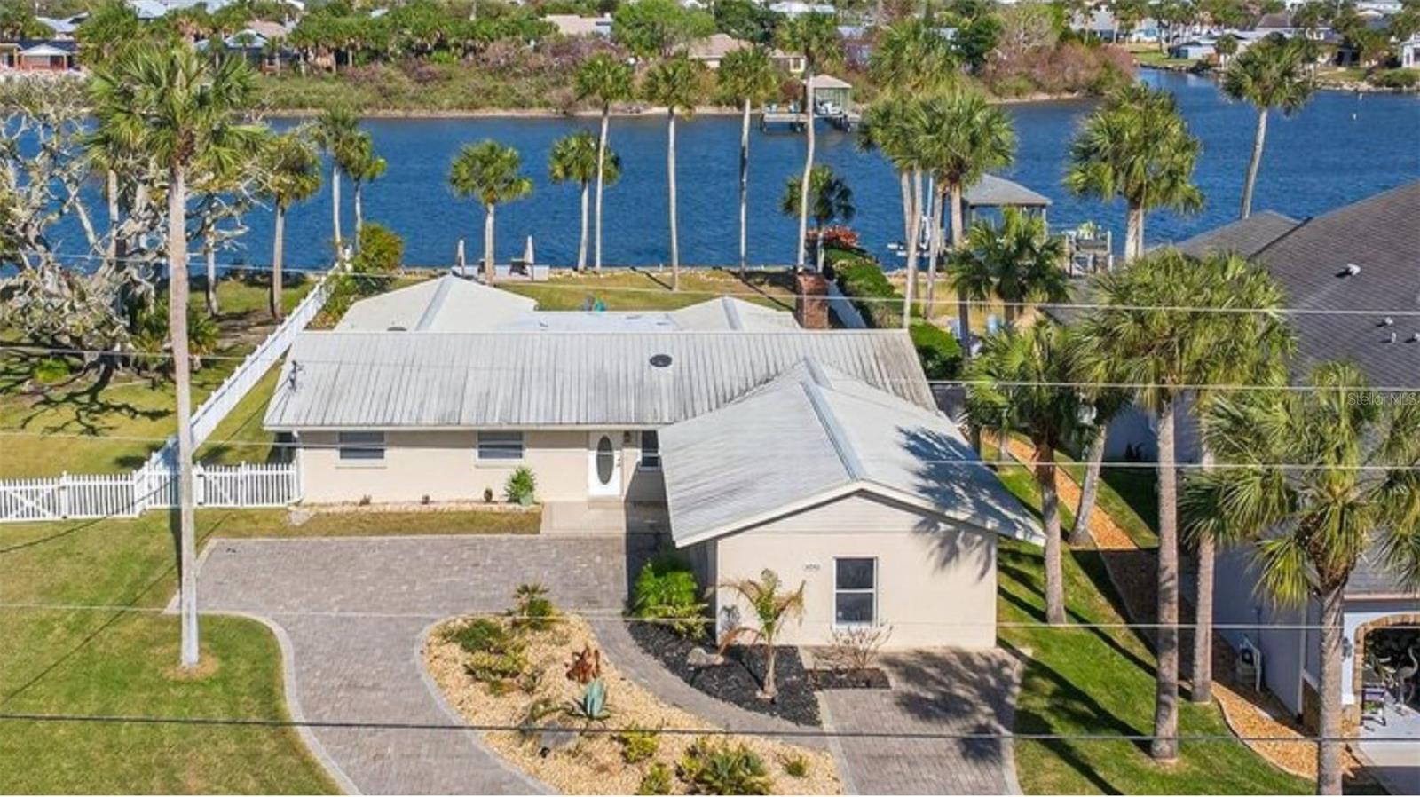 Welcome to your private waterfront retreat in beautiful Flagler Beach, where riverfront living meets comfort, space, and coastal charm. This beautifully updated 4-bedroom, 3-bathroom single-family home sits on a spacious lot along the river, offering stunning natural surroundings, lush tropical landscaping, and swaying palm trees that create a true Florida paradise in your own backyard. Inside, the home features an open and inviting layout with tile flooring throughout the main living areas and soft carpeting in the bedrooms for added comfort. The living room is anchored by a cozy wood-burning fireplace, creating a warm gathering space while still embracing the relaxed coastal lifestyle. The updated kitchen is designed for both function and style, complete with modern finishes and a built-in wine cooler, making it perfect for entertaining or enjoying quiet evenings at home.

The spacious floor plan offers four well-appointed bedrooms and three full bathrooms, providing plenty of room for family, guests, or a dedicated home office. One of the standout features of the home is the elegant clawfoot soaking tub with a shower, adding timeless character and spa-like charm to the bathroom. Step outside and experience the true highlight of this property — the expansive backyard overlooking the river. Mature palm trees, lush landscaping, and a large yard create a peaceful outdoor oasis with endless potential for entertaining, relaxing, gardening, or enjoying waterfront sunsets.

The generous lawn and scenic waterfront setting also make this property uniquely suited for hosting outdoor gatherings, private events, or even small wedding celebrations. With its picturesque river backdrop, tropical landscaping, and wide open lawn space, the backyard creates a stunning natural venue for memorable occasions. Photos from a recent wedding hosted on the property showcase just how beautiful and functional this space can be for special events.

Additional features include a rare 2.5-car garage, providing ample space for vehicles, storage, golf carts, or recreational equipment. Located in highly desirable Flagler Beach, this property offers easy access to the beach, boating, fishing, local restaurants, parks, and scenic coastal drives. If you’ve been searching for a Flagler Beach waterfront home, riverfront property, or a spacious coastal Florida home with a large yard, tropical landscaping, and room for entertaining, this beautifully maintained property offers the perfect blend of location, lifestyle, and opportunity.