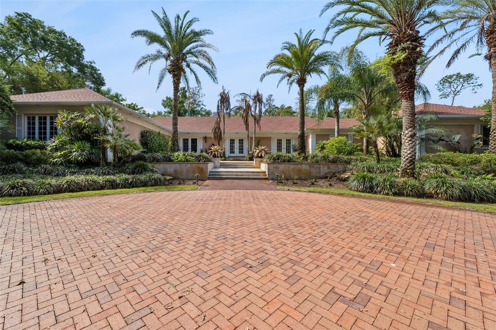 Experience elevated living in this beautifully designed home, set within the exclusive community of Mountain Lake. Tucked away along a private, tree-lined drive, this serene property spans nearly two acres of lush, manicured grounds, offering exceptional privacy. Renovated in 2012, the home features a stylish, Tuscan-inspired kitchen with granite countertops, a gas range, and an open layout perfect for entertaining. Sun-filled interiors highlight a well-planned three-bedroom, three-and-a-half-bath design that blends comfort with inviting gathering spaces. The spacious primary suite offers a spa-like bath, dual walk-in closets, a cozy coffee bar, and a private terrace. Outside, enjoy resort-style living with a sparkling pool, screened lanai, pergola-covered patio, and nearby citrus grove. With a new roof installed in 2023, this move-in-ready home delivers the perfect mix of luxury, privacy, and convenience. Schedule your private showing today.