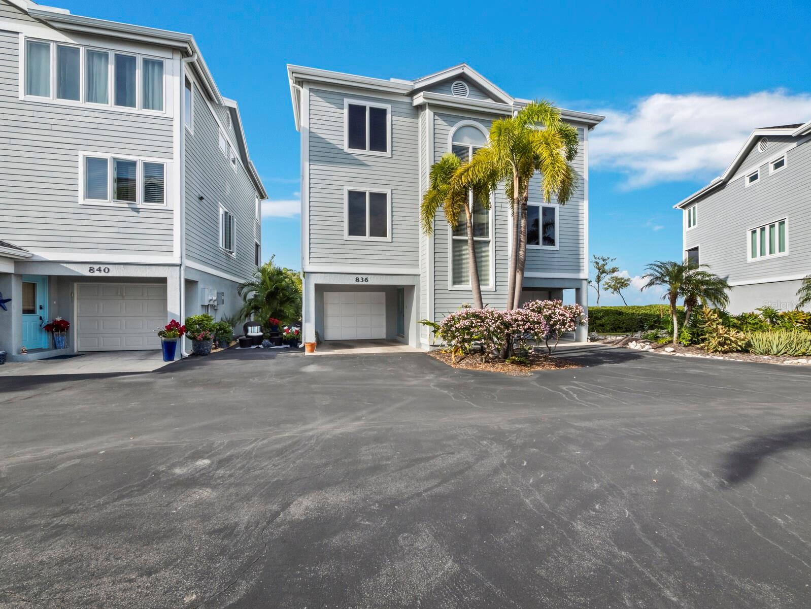 Bay Views! Investor Dream Home!  A double condo unit which feels like a single-family home, because it is not attached to anything but sunshine, the bay and dreams! Elevated among the treetops on the bay side of Longboat Key, it features 2 oversized garage spaces, wood floors throughout the first elevated living level, an open great room with a large open kitchen for entertaining, an inviting wood-burning fireplace, screened lanai for bay breezes and a office/den/flex room. Upstairs you will find 2 guest bedrooms which share a full bath and a primary bedroom with a view of Sarasota Bay through a wall of windows and a screened lanai where you can catch the sunset glow over the treetops. The ensuite primary bath features dual sinks and 2 large walk-in closets. Amenities in the premier tennis community include exceptional access to Bay waters, perfect for launching a kayak, fishing and enjoying the tide pools.  Enjoy a boardwalk stroll through mangroves and watch the sunrise from a private bayside dock (no boat access). Pool membership comes with home ownership.  Tennis, pickleball and fitness center access is available through Cedars East Resort at an annual rate.  Update, redesign and make it your home or income opportunity today!