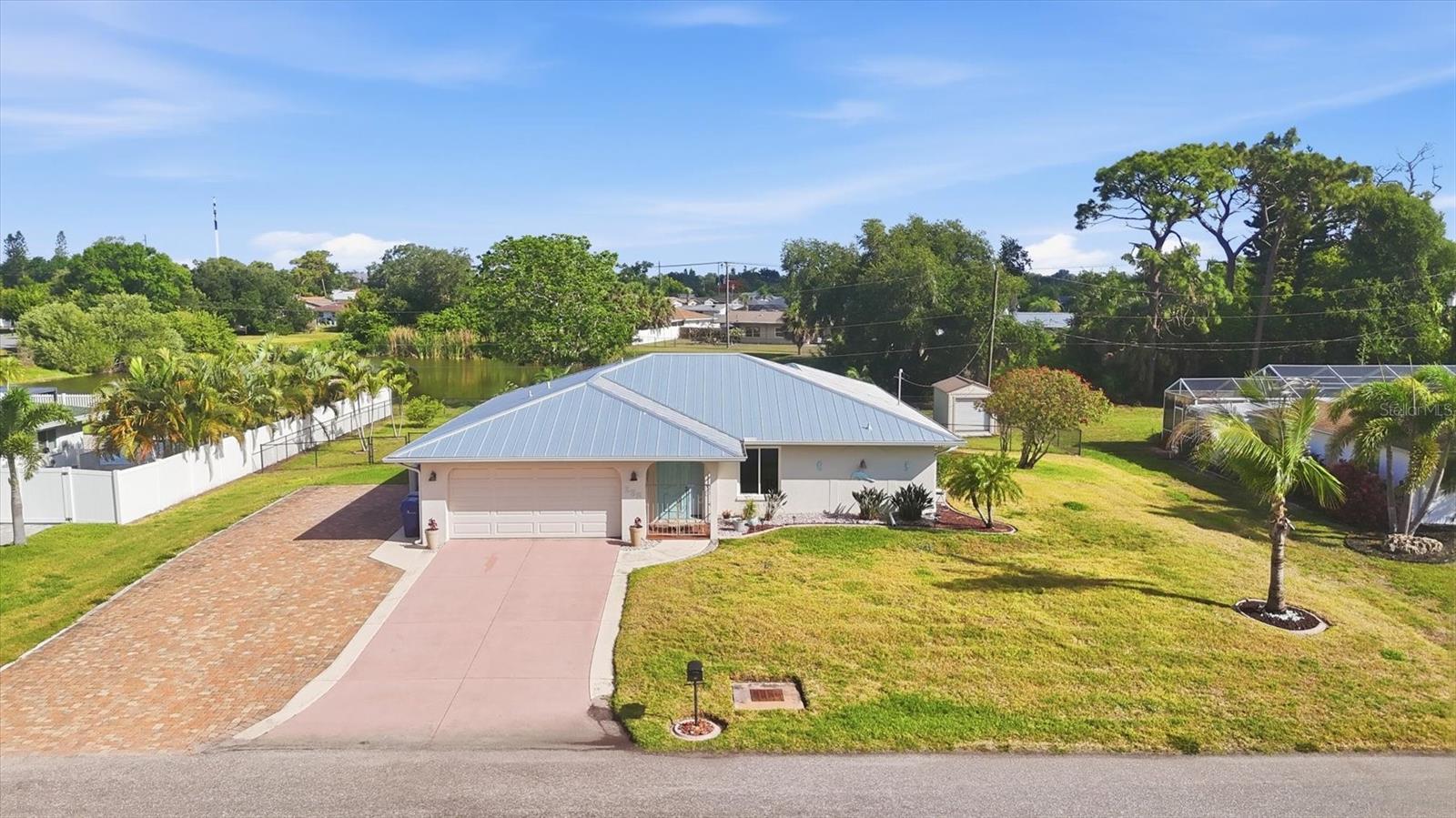 One or more photos have been virtually staged.  Flexible bonus room is ideal for a third bedroom, home office, hobby room, or den.  Situated on an oversized lot with a peaceful pond view, this move-in ready home shows true pride of ownership with no deferred maintenance! Major updates include a new metal roof (2021), septic system (2024), patio roof (2023), well pump (2021), hot water heater (2020), and sprinkler pump & lines (2024). 11 hurricane rated windows in 2024.  Fully fenced backyard with black chain link fence.  Interior features include tile floors throughout, updated kitchen and primary bath, inside laundry,  Extended paver driveway offers extra parking for your boat, motor home, truck, or additional vehicles. Generator outlet already in place. Additional storage provided by the 8x12 shed. Florida room is not air conditioned. Conveniently located just minutes from downtown Venice and its beautiful Gulf beaches.