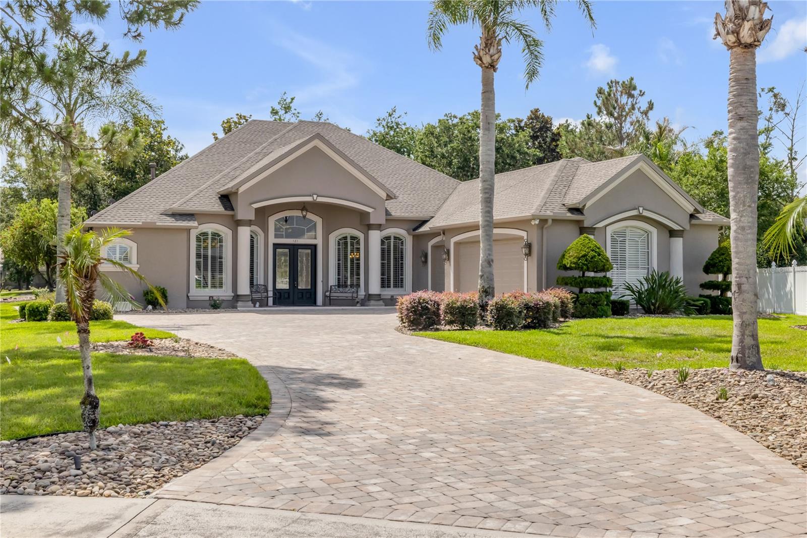 This beautifully updated 4-bedroom, 3-bath pool home is positioned on an expansive half-acre lot overlooking the 16th hole, offering a rare combination of golf course views, privacy, and refined Florida living. With nearly 3,000 sq. ft. of living space, the home delivers a polished blend of comfort and elevated design. A grand approach welcomes you with an extended paver driveway, side-entry garage, and lush tropical landscaping. Double glass entry doors open to a light-filled interior with soaring ceilings, crown molding, and an immediate sense of openness. The kitchen has been fully updated and serves as a true centerpiece of the home, featuring new cabinetry, quartz countertops, abundant storage, and high-end appliances designed for both everyday cooking and entertaining. It flows seamlessly into the main living spaces, creating an ideal layout for gatherings. New tile flooring extends through the main living areas, hallways, guest baths, and utility room, while engineered hardwood enhances the primary suite. Updated 5 1/4” baseboards and cohesive finishes throughout the kitchen and bathrooms add a clean, modern luxury feel. The main living area offers a warm and inviting atmosphere with custom built-ins, a gas fireplace, and a dry bar with wine cooler. Triple sliding glass doors open to the screened lanai, creating effortless indoor-outdoor living. The primary suite enjoys private backyard and golf course views with lanai access, along with a spa-inspired bath featuring dual vanities and quartz finishes. Secondary bedrooms are well-sized and updated, providing comfort for guests or family. The outdoor living space is the highlight, featuring a heated pool and spa with water features, a fully equipped outdoor kitchen, and wide golf course views that create a true resort-style setting. Additional highlights include an oversized garage with golf cart space, generator connections, and a well-appointed laundry room with storage. A refined golf course residence that combines thoughtful upgrades, strong design, and an exceptional location. Mortgage savings may be available for buyers of this listing.