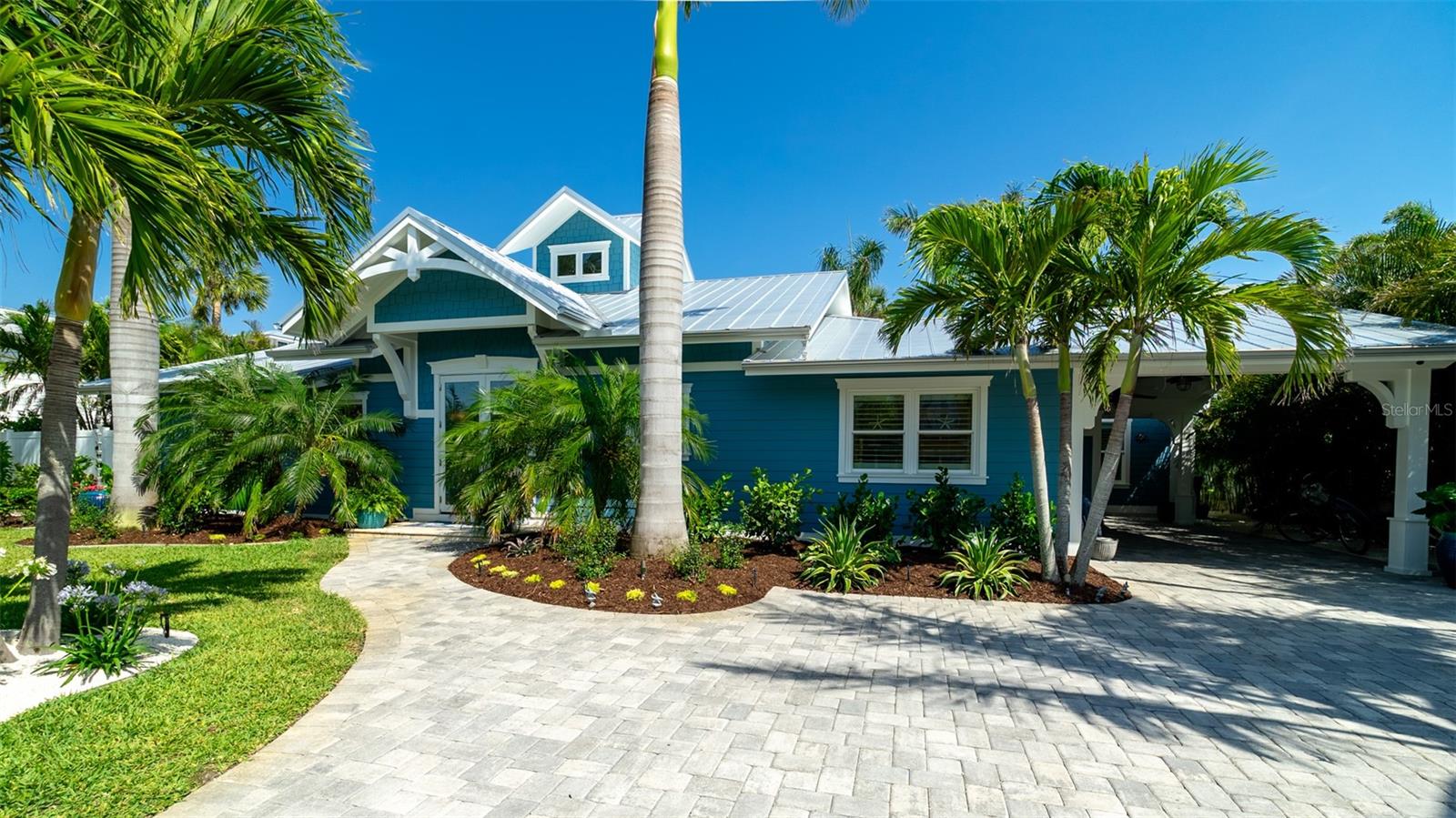 Charming Coastal Cottage in Holmes Beach. Welcome to this newly and meticulously remodeled coastal retreat, ideally located in the heart of Holmes Beach. This one-of-a-kind, artsy beach cottage blends timeless charm with modern elegance and smart technology. Step through the inviting rain glass double doors into a spacious open-concept living, dining, and kitchen area, where a dramatic lighted cupola and vaulted ceilings create a stunning first impression. A custom shell stone fireplace with a wood mantle adds warmth to the cozy seating area—perfect for relaxing or entertaining. The chef’s kitchen is a true showstopper, featuring an oversized, lighted quartz island with seating, beadboard cabinetry, and a custom wave-patterned glass backsplash. High-end appliances include an ILVE Majestic 4-burner gas stove with griddle, GE Café refrigerator, wine fridge, and porcelain farm sink—all designed with entertaining in mind.Craftsmanship continues throughout with custom millwork, shiplap accents, paneled walls, and solid-core doors. Oversized sliding glass doors open to reveal a tropical backyard oasis, complete with a free-form heated pool and spa, paver patio with artificial turf. The lush, mature landscaping with up lighting show off the tall palm trees, perfect for a evening cocktail party under the stars. The southern-facing yard is perfect for dining, lounging, and soaking up the sun. Each of the three bedrooms and 2.5 baths showcases custom chrome period fixtures, retro-inspired sinks, and designer details. Tech-savvy buyers will love the smart home features, including Lutron lighting controls, LED lighting, Sonos sound system, security cameras, and plantation shutters.  The property includes a 250-gallon buried propane tank serving the on-demand water heater, gas grill, pool heater, and stove. It’s also generator-ready with existing plumbing and wiring in place. There is city dockage close by for boating enthusiast's This extraordinary home offers a rare blend of beachy charm and premium amenities including a "She Shed" which offers additional luxurious living space.  Words cannot describe the uniqueness of this feature so call now for your private showing of this amazing property.