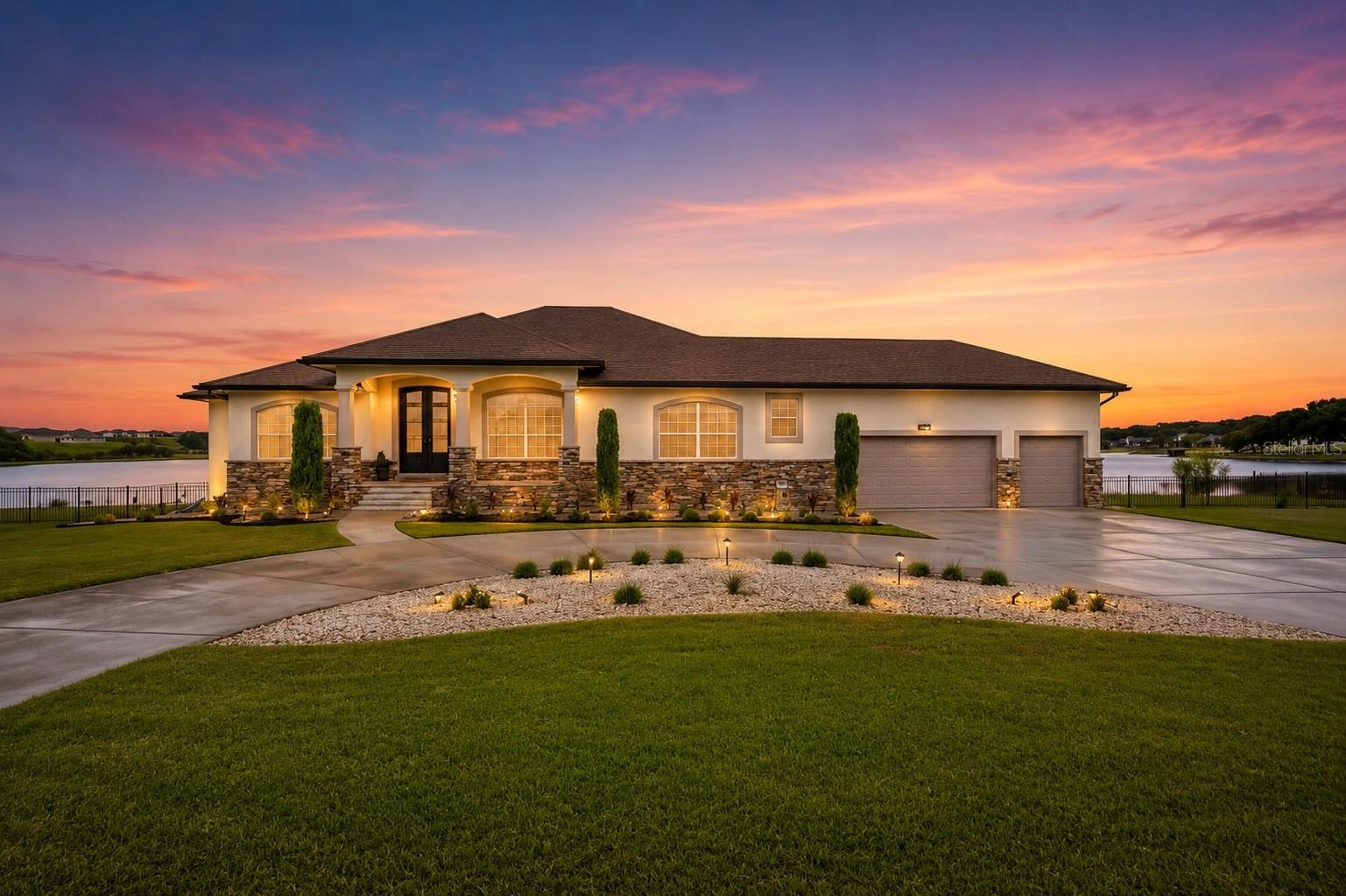Welcome to 5911 Old Berkley Rd, a truly extraordinary lakefront estate nestled along the pristine shores of Lake Tennessee in north Auburndale. Set on over half an acre in a prime location just off Interstate 4, this 5-bedroom, 4.5-bath custom residence offers 4,281 square feet of beautifully designed living space, thoughtfully crafted for families who want luxury living with easy access to both Tampa and Orlando. The elevated main level serves as the heart of the home, where expansive windows frame stunning views of the pool and lakefront beyond. The open-concept living and dining areas flow seamlessly into a chef’s kitchen appointed with quartz countertops, wood cabinetry, and premium appliances—an ideal layout for entertaining or everyday family life. Just off the main living area, you’ll find two dedicated offices—perfect for a his-and-hers setup, private den, or a quiet study and creative space. The owner’s suite is a serene retreat with panoramic lake views, private porch access, and a spa-like ensuite bath featuring dual vanities and an oversized walk-in shower. A guest suite, powder bath, and laundry room complete the upper level. Downstairs, the walk-out basement-style lower level offers three additional bedrooms, two full bathrooms, and a spacious second living room/game room with direct access to the pool and lake—perfect for guests or multigenerational living. The outdoor living spaces are equally impressive. A large covered patio leads to a sprawling pool deck and private backyard oasis. Beyond the pool, your private boat dock with covered slip and electric lift awaits—ready for summer tubing, paddleboarding, or a sunset cruise. A rear storage room is perfectly placed to hold all your pool and lake toys. The oversized 3-car garage offers high ceilings and abundant storage, ideal for boats, vehicles, and gear of all kinds. This property blends refined interiors, functional design, and lakefront serenity with unmatched location convenience. Whether you're commuting to the city or enjoying the quiet escape of lakeside living, this is a one-of-a-kind opportunity to own a private retreat in one of Central Florida’s most desirable areas.
