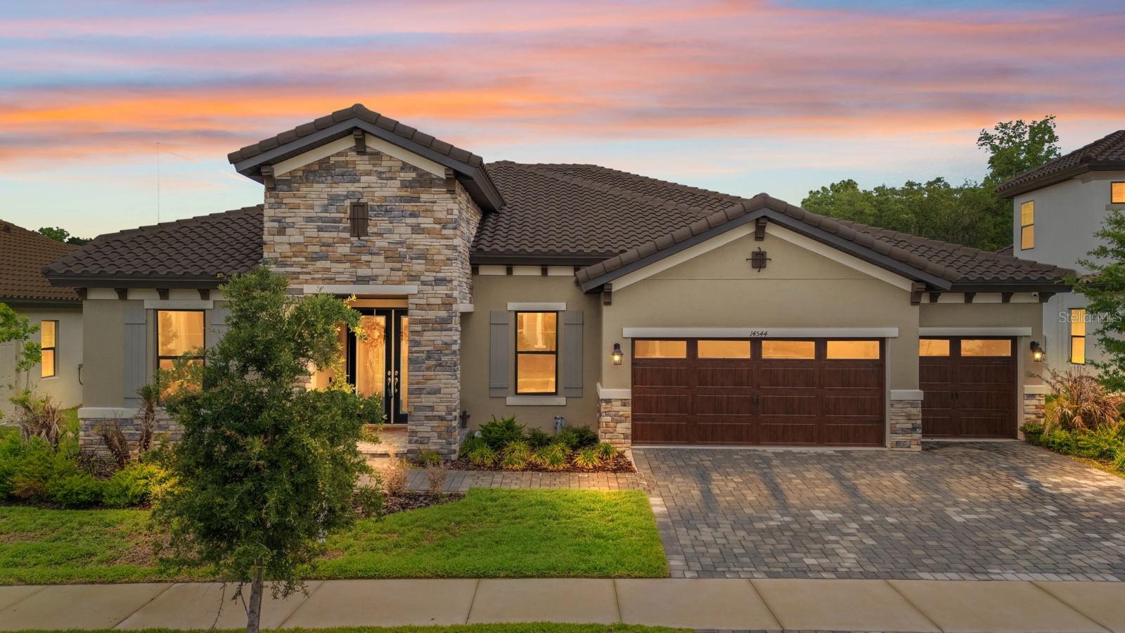 Welcome to the resort-style Hinton Hawkstone community, where this stunning 2023 executive home is move-in ready, with no rear neighbors. This spacious 4-bedroom, 3-bathroom home also includes a private office and a large bonus room, providing flexibility for everyday living or entertaining. From the curb, the home stands out with its tile roof, elegant archways, and pavered driveway leading to a 3-car garage. Inside, you’re greeted by a formal living area and a dedicated office before stepping into the open-concept great room, designed for both comfort and functionality. Throughout the home, you’ll find carefully selected upgrades, cohesive color tones, and stylish finishes that truly shine in person. The primary suite offers a private retreat with a generous walk-in closet and a spa-inspired bathroom featuring dual granite vanities, a soaking tub, and a walk-in shower. The split-bedroom layout provides added privacy, while the versatile bonus room, currently used as a fitness and play space, can easily be converted into a media room, game room, or additional living area, with direct access to the backyard. Additional features include ample storage, an indoor laundry room, and a covered patio that’s pre-wired and plumbed for an outdoor kitchen ideal for creating your perfect outdoor entertaining space. Enjoy the peaceful, tree-lined backyard with no rear neighbors for added privacy. Smart home features such as a security system, whole-home speaker system, and smart thermostat add convenience and modern appeal. Residents of Hinton Hawkstone enjoy access to resort-style amenities, including a lagoon pool with splash pad, lap pool, pickleball courts, playground, dog park, and more, all conveniently located near top-rated Lithia schools.