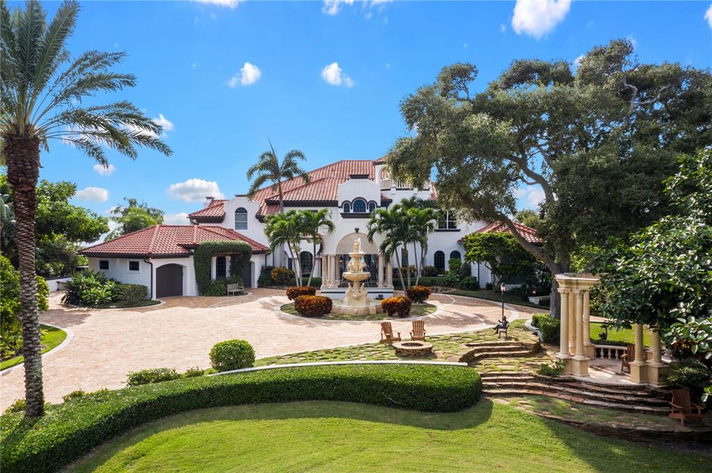 Exquisite riverfront estate, perfectly perched upon one of the highest points in Merritt Island. Located on almost 8 acres, this stunning residence is bordered on one side by Honeymoon Lake and the Indian River and on the other side by the Banana River offering amazing water views from practically every room in the house. As you enter through the private gates and begin the drive up the 300 ft. long travertine marble drive, your eyes are immediately greeted by the impeccable grounds and unparalleled architectural details. The home features whole-house automation with state-of-the-art technology from Crestron. Interior amenities include a modern chef's kitchen with European styling, a massive center island, top-of-the-line appliances, and striking exotic granite countertops. The expansive master suite features a seating area with a private fireplace, a huge outdoor balcony, and a one-of-a-kind spa bath for soaking away the stresses of a long day. There is also a separate guest suite, home theater, library, huge game room, and a fitness center. The exterior of the home is an entertainer's dream featuring an enormous covered lanai with a summer kitchen overlooking the resort-style infinity-edge pool and the private boat dock on the water. Positioned right in the middle of Florida's Space Coast and just 40 minutes from the international airport and all of Central Florida's attractions, the location is hard to beat.