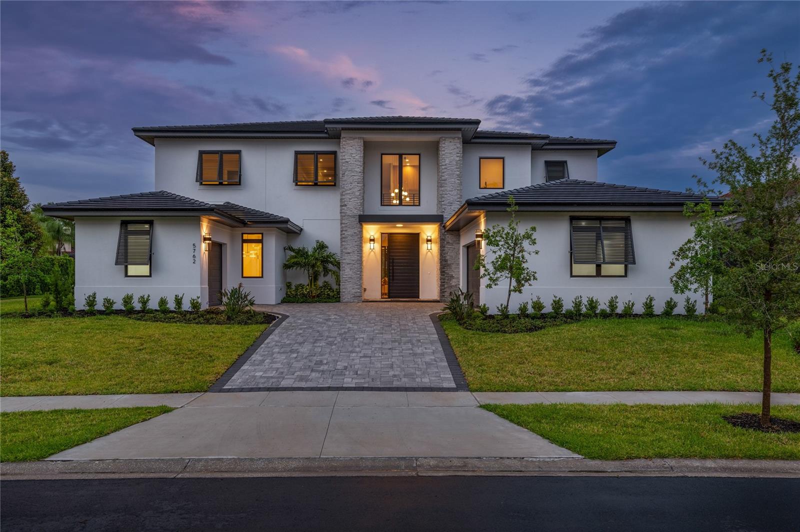 Extraordinary new construction residence by renowned builder Davila Homes, situated in the prestigious 24-hour guard-gated community of Emerson Pointe. Boasting over 5,100 square feet of thoughtfully curated living space, offering a seamless fusion of sophistication and functionality in the heart of Dr. Phillips. As you step through the custom metal front door, you're immediately greeted by the grand entryway featuring soaring ceilings, and an abundance of natural light that fills the open concept layout creating an inviting ambiance throughout. The heart of the home is the expansive chef’s kitchen, outfitted with top-of-the-line Thermador appliances, custom cabinetry, and an oversized center island with a waterfall edge, seamlessly flowing into the living and dining areas.  The primary suite is a true sanctuary, featuring a spacious bedroom, a huge walk-in closet, and a lavish en-suite bath with a soaking tub, dual vanities, and a large walk-in shower. This home features four additional bedrooms that all have walk-in closets and en-suite bathrooms, and a large bonus room on the second floor. Step outside to your own private outdoor oasis featuring a large sparkling pool with a beach area, a spacious covered patio equipped with a full summer kitchen, and a large, fenced yard with a pergola. Additional features include a two-car garage plus a golf cart garage, and stunning high-end finishes throughout. The Bay Hill lifestyle features country club dining, tennis, fitness center, and of course the famed Arnold Palmer golf course. The location can’t be beaten, just minutes from restaurant row, world-class shopping, and all the area theme parks. The ability to own a brand new home in this highly sought after community doesn’t come around very often. Don't miss the opportunity to make this extraordinary home yours.