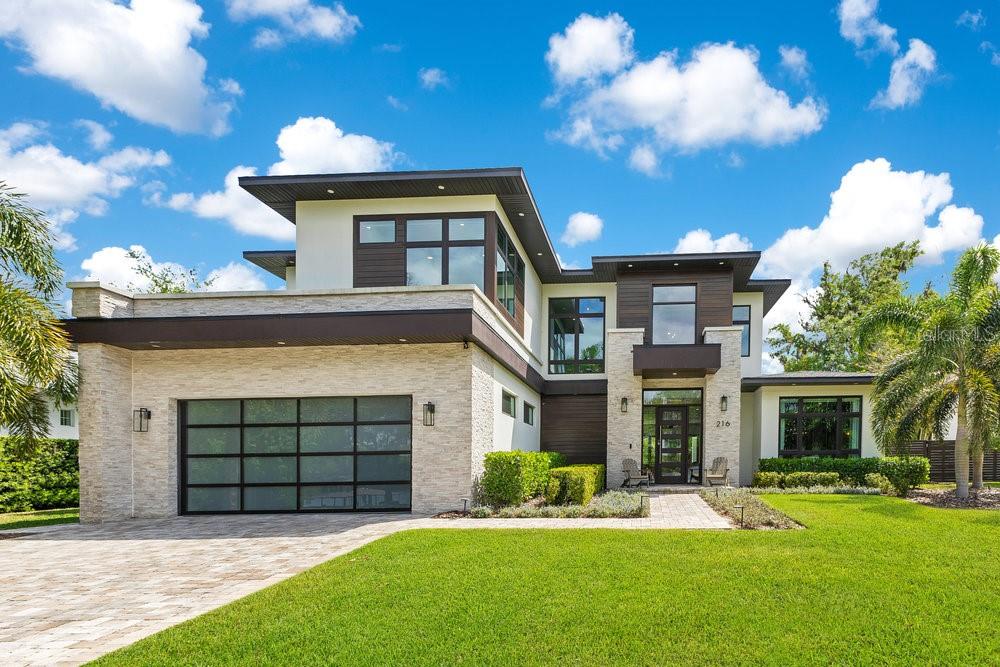 Exquisite Lakeview pool home, built in 2021, combines modern elegance and timeless style. Located in the heart of Maitland, with front-row seats to unforgettable sunsets over Lake Sybelia! This Five bedroom, Five and a half bath residence boasts 4,697 square feet of tastefully designed living space. Inside you’re met by a grand foyer and airy layout flooded with natural light, soaring ceilings, wide-plank hardwood floors, custom window treatments, and designer finishes throughout.
The gourmet kitchen is an entertainer's delight-equipped with top-of-the-line Wolf and Sub-zero appliances, Taj Mahal quartzite, stunning 12-foot waterfall island, 48” 8 burner gas range with pot filler, large walk-in pantry, with butler’s pantry adjoining the kitchen and dining— the open concept design is perfect for both entertaining and every day living. The living room’s quartz-accented fireplace and sleek glass folding doors provide a seamless flow between indoor and outdoor living. Retreat to the primary suite's spa-inspired bathroom with custom designed walk-in closet, dual vanities, soaking tub and double walk-through shower. A sleek cable railing staircase leads to four generously sized Bedrooms-three with ensuite baths, four bathrooms, a designated Office and versatile Loft/Flex space. Enjoy breathtaking lake views whether working or unwinding! Equally impressive is the beautifully landscaped outdoor living space, with expansive covered lanai, multiple lounge areas, fully equipped summer kitchen, gas fire pit and luxurious salt-water pool and spa. Property features smart home technology, custom closets systems, remote controlled window treatments, surround sound, full-house generator, 500 lb propane tank, 3 car garage with epoxy flooring and so much more! A short walk to Lake Lily and the Maitland Farmers Market, and minutes to Winter Park and I-4.  This exceptional home combines refined luxury with an unbeatable location. Don’t miss out on this rare find!