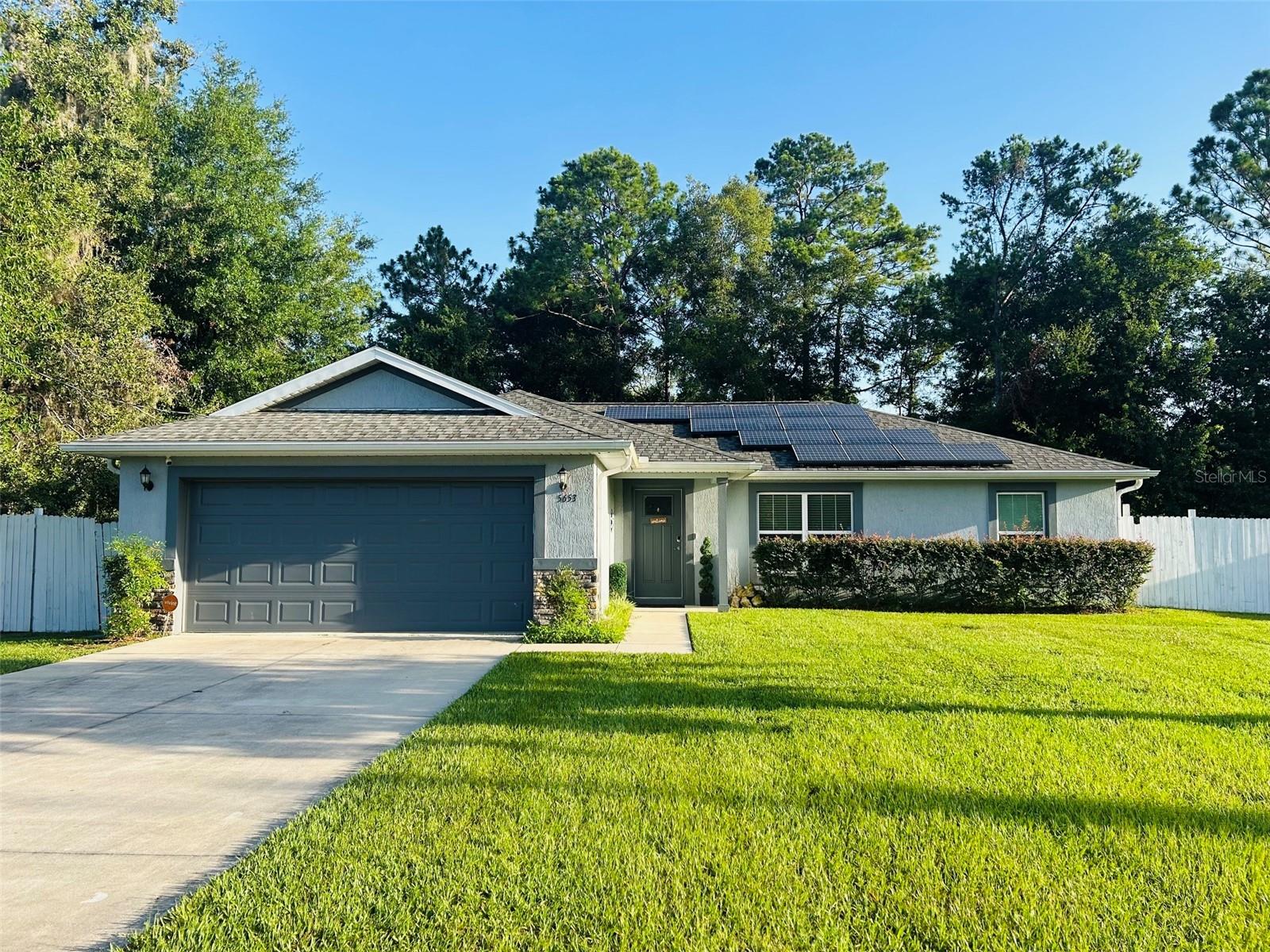 Nestled in picturesque Ocala, this impeccably maintained 3-bedroom, 2-bath home, built in 2020, offers the perfect blend of modern comfort and peaceful, serene living. Designed with a desirable split-bedroom floor plan, this move-in-ready home features an open-concept layout that’s ideal for both everyday living and entertaining. The heart of the home showcases an upgraded kitchen with beautiful cabinetry, granite countertops, a breakfast bar, and ample space to gather with family and friends. Additional upgrades include an electric fireplace, solar energy system, water softener, new glass shower enclosures, freshly painted interior and an attached two-car garage for added convenience. Step outside to your covered lanai overlooking a lush, private backyard that backs to conservation, creating a tranquil setting to enjoy morning coffee, evening cocktails, or relaxing around the fire pit under the stars. Ideally located near Ocala’s renowned equestrian community, world-class horse farms, shopping, dining, entertainment, medical facilities, schools, parks, and historic Downtown Ocala. Outdoor enthusiasts will appreciate the close proximity to Silver Springs State Park, Ocala National Forest, scenic hiking trails, boating, kayaking, and countless recreational opportunities. Experience the best of country charm with modern conveniences just minutes away—this exceptional home is ready to welcome you.