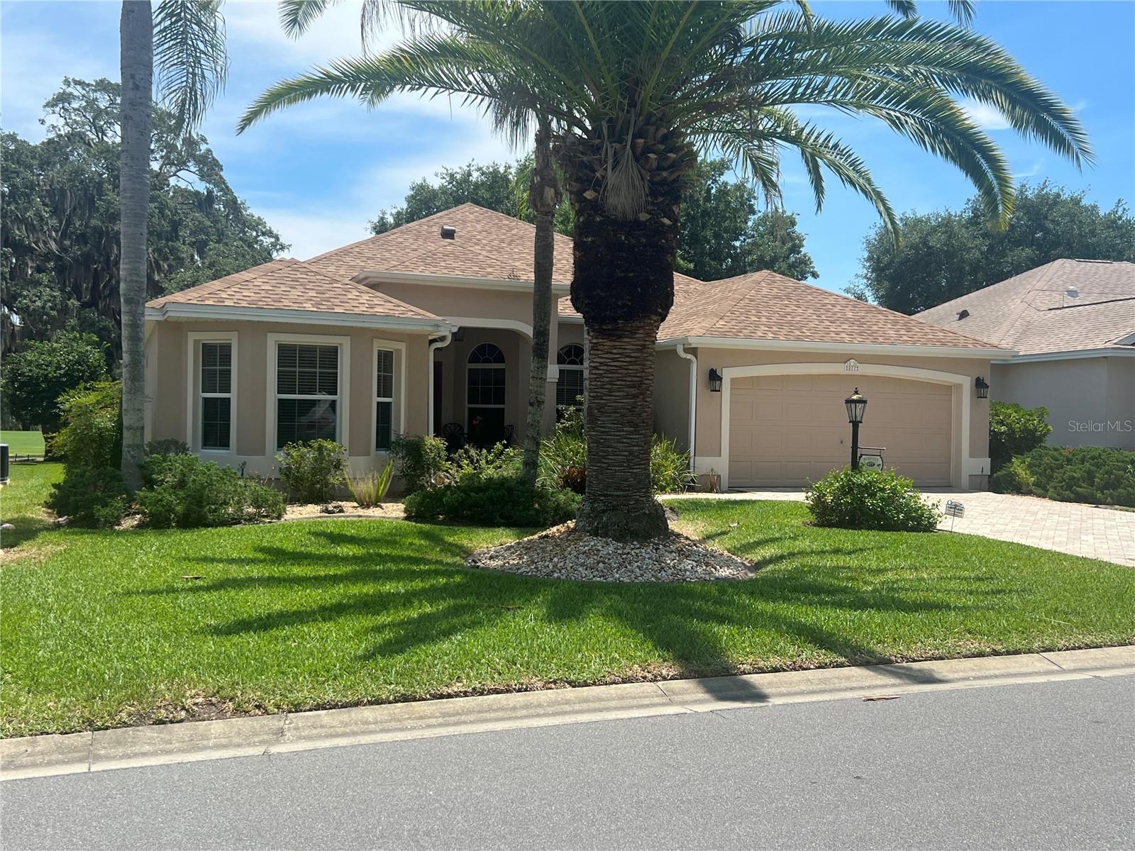 Make your new home, this spectacular location in the Village of Winifred, on Winifred Way.  Strolling the cobblestone driveway, to the front door, you will notice the charm immediately.  Upon entering, you can see the large Oak Trees with Moss dripping onto the very first hole of Laurel Valley on the beautiful Palmer Legends Championship golf course.  You can literally walk down the street to the Palmer Club from this spectacular home. NO BOND! COMPLETELY TURN KEY! The kitchen and breakfast nook sits just to the right of the entry foyer.  The kitchen has built-ins, tall ceilings, and tall lovely cabinets.  Following the foyer hallway, the large living room sits to the left and the large, beautiful dining room to the right. Both have amazing views of the large lanai and birdcage beyond overlooking the golf course and huge preserve beyond.  The view is spectacular! Following to the right of the foyer and past the dining room, to the left is the Primary suite, with another sliding door to the lanai, and amazing views of the golf course.  The primary suite has two walk-in closets, a double dressing area, and large shower area.  Across the hall from the Primary suite, sits the laundry room, leading to the large garage with painted epoxy floors.  Back to the front Foyer, is a door leading to what is now a study, with built in desk and bookshelves, a couch and sofa bed.  This can serve as a bedroom. The Jack and Jill bathroom with shower and tub separate this room from a large guest bedroom and built in closet. New Roof, 2020.  A list is available of all upgrades for the life of the property.  To the north just three roundabouts away, sits the Laurel Manor Rec Center and 466, close to shopping galore, the newly opened Costco and many restaurants and stores.  The neighborhood is also close to Lake Sumter Landing with shops, restaurants, live music nightly. Come make this your permanent home and perfect location for the Villages lifestyle!