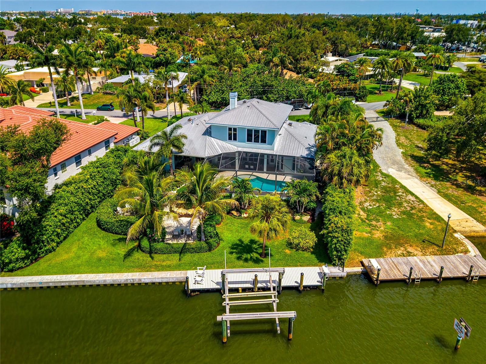 Imagine having your own private outdoor paradise designed for a relaxing life on the water. This custom designed Key West style residence in Southpointe Shores offers deep sailboat water on a rare wide natural bayou with more than 100 feet of waterfront, complemented by a new Atkins seawall, a 30 foot Cool Touch dock, a 27,000 pound boat lift, second wet slip capability, and a fish cleaning station.

Built by Graber Homes and extensively and beautifully renovated, the residence features an open floor plan with living and dining areas that transition naturally to the kitchen and waterfront. Renewal by Andersen sliding doors frame the canal and provide direct access to the outdoor living spaces. Travertine flooring extends throughout the entire first level.

The kitchen includes fine wood custom Campbell Cabinetry, Calacatta marble countertops and backsplash, a large entertaining island, a walk in pantry, and gourmet appliances featuring a new Sub Zero refrigerator, a Wolf wall oven, two Miele dishwashers, a Miele coffee station, and a 48 inch Fulgor Milano induction range.

Additionally, the first floor offers a roomy primary suite with two walk in closets and an updated Campbell Cabinetry bath with dual vanities, a walk in shower, and a clawfoot tub, along with a pool bath and an oversized laundry room.

The second level offers two guest bedrooms, a full bath with a marble walk in shower and Campbell Cabinetry, and a large bonus room currently arranged as a home gym. New wood look tile flooring extends throughout the second floor.

Outdoor spaces include a 7 foot deep saltwater pool and deep seat gas heated spa, a built in 48 inch Lynx outdoor kitchen, professionally designed Artistic paver patios and walkways, a gas fire pit in a private seating area, a second patio for sunbathing, and a stunning landscaped pond with waterfalls inspired by Marie Selby Botanical Gardens. The home also features a 14 speaker indoor and outdoor NHT sound system for entertaining.

The entirely fenced backyard provides privacy with direct access to the dock and waterfront.

Recent improvements include a whole house 26KW Generac generator, three new Bryant HVAC systems with new ductwork and Knauf insulation, an Aprilaire whole home fresh air and dehumidification system, whole house water filtration, new Starlink internet, two 48 amp Tesla charging stations, and a large air conditioned three car garage with hanging rack storage along the ceiling.

Located West of the Trail, Southpointe Shores offers a friendly optional HOA, a private gated neighborhood boat ramp and park, and easy access to Midnight Pass, Sarasota Bay, Siesta Key, downtown Sarasota, shopping, and dining.