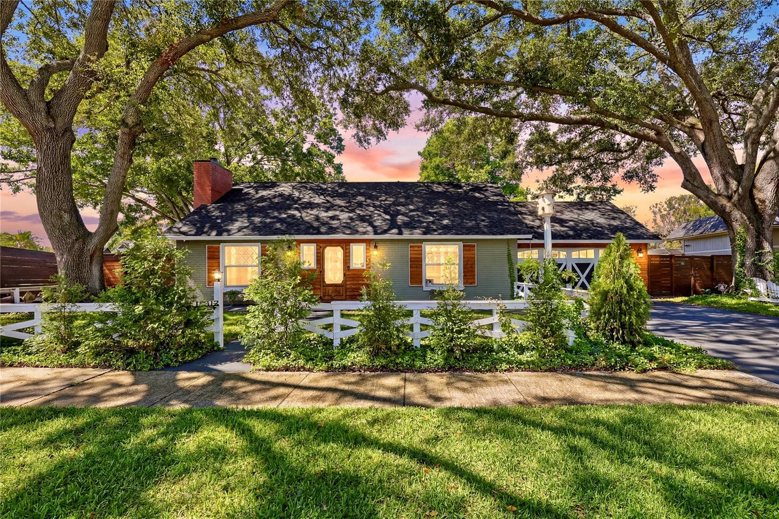 Tucked beneath mature trees on the shore of peaceful Lake George, this one-of-a-kind cottage-inspired retreat offers a rare blend of character, comfort, and connection to nature. Storybook charm meets modern lakefront living in this 4-bedroom, 3.5-bath cottage-style home on a serene waterfront lot in the sought-after Lake Magdalene area. With 2,819 square feet of thoughtfully designed living space, this home offers a rare combination of character, flexibility, and lovely natural surroundings. The exceptional curb appeal sets the tone. Inside, custom stained-glass details, natural wood accents, and unique architectural touches create warmth and personality throughout. The spacious kitchen with adjoining living area is designed for gathering and entertaining, featuring a large island, custom cabinetry, Elmira and Fisher Paykel appliances, and a walk-in pantry.  Formal dining room with French doors overlooking the pool and lake; formal living room with wood-burning fireplace.  
*****************************************************************************************************************
The flexible floor plan includes two en suite bedrooms on the first floor.  The primary retreat offers a vaulted ceiling and French doors overlooking a fire pit area and the lake. A multi-generational living space (behind a hidden door) offers a roll-in shower with a built-in seating area and a detachable shower head.  Upstairs are two bedrooms, each offering its own sitting area with glass doors overlooking the pool and lake, creating private spaces to relax and enjoy the view.  They share a large full bathroom.  Large laundry room downstairs with cabinetry, folding area, and hanging space, and a dedicated laundry area upstairs. Outdoor living is equally impressive with an updated pool, expansive Trex deck, private dock, and direct access to the scenic lake for kayaking, paddleboarding, fishing, or simply enjoying the peaceful waterfront setting. Recent improvements include a new roof (2026), two new HVAC systems (2025), retractable screen doors, new chimney exterior, lawn sprinklers, custom solid wood fencing, and fresh interior and exterior paint (2025-2026), providing both style and peace of mind. A truly special property where timeless cottage charm and modern convenience come together in an unforgettable lakefront setting. Commuting is a breeze with close proximity to I-275 and Dale Mabry Highway, putting Downtown Tampa, Tampa International Airport, the University of South Florida (USF), and top-rated medical centers just a short drive away. Spend less time in traffic and more time enjoying the nearby Golf Courses, local parks, and the vibrant dining scene right outside your backyard.