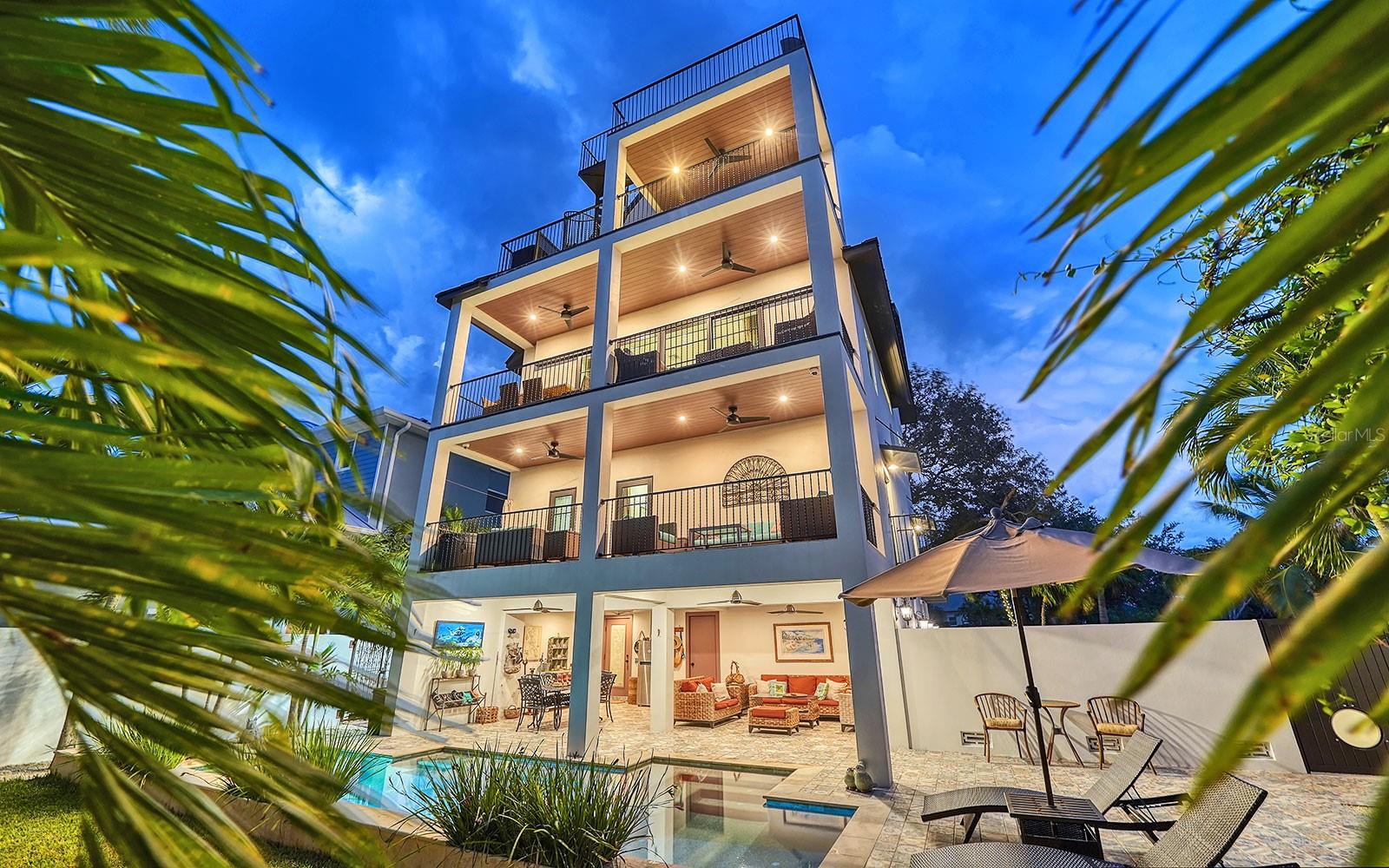 Welcome home to the house that dreams are made of. This magical residence is located on the quiet side of Siesta Key Village, yet very much in the midst of its local flavor -- the beach, the village, a private boat dock, and the positivity of year-round awe-inspiring sunsets. Built by the owners, a design/build dynamic duo, as their personal retreat, every detail is carefully considered and executed. Eclectic finesse and fine craftsmanship define the 3,122 sq. ft. residence where a tasteful mix of textures, shapes and light invoke the timeless appeal of a rare masterpiece. Completed in 2018, everything about this home feels safe and new: Levels one, two and three are concrete block. Level four is two-by-six wood frame. All glass is impact rated to 160 MPH. Standing seam metal roof. Six-foot privacy wall with keypad-protected metal security gates. A three-way elevator provides access to all floors, as does the free-floating steel staircase with floor-to-ceiling glass-panels that provide open sightlines of the living areas. Level three is home to the open-concept living room, dining room and kitchen. Private quarters are on levels two and four. Every floor has a sizable covered balcony. There’s even a grilling balcony by the kitchen. For the piece de resistance, a spiral staircase leads from the fourth-floor balcony to a roof-top balcony with views of Siesta Village, Siesta Beach, Downtown Sarasota and multiple 4th of July firework displays. Down on the ground level, you’ll find a two-car garage, plus a massive 440 sq. ft. covered lanai adjacent to the refreshing outdoor pool. Across the driveway is a private boat dock with 10,000-lbs. lift and room for a second lift. Access to the bay is via a canal with 13-ft. clearance at the Midnight Pass Road bridge. Siesta Village is a wonderful, walkable neighborhood filled with restaurants, shops and personal services. The best attraction is the classic stroll down to the beach to watch the sunset. It stirs the soul and guarantees that Siesta Key will always be a great place to live.