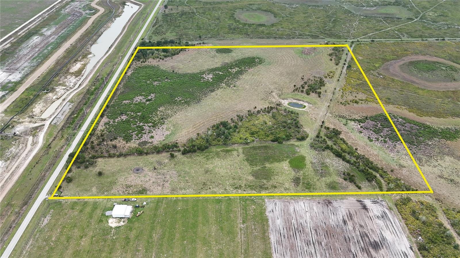 Located in southern Polk County, this 40.11± acre property offers a combination of open pasture, convenient access, and a rural setting suitable for a variety of land uses. Featuring more than 1,300 feet of paved road frontage along County Line Road E, the property provides year-round accessibility for agricultural operations or the construction of a future residence, subject to county zoning, permitting, and other applicable regulations.

Electric service is available along the road, offering added convenience for future improvements. The property is fully fenced and currently zoned as pasture, making it well-suited for livestock grazing and other agricultural activities. The level terrain allows for efficient movement of equipment and livestock while providing flexibility for agricultural infrastructure or other improvements consistent with local requirements.

A pond located on the property serves as a natural water source for livestock and wildlife while adding another functional feature to the landscape. Open grassy pasture provides usable acreage with minimal site preparation needed for continued agricultural use. Whether maintaining cattle, supporting other livestock operations, or simply enjoying the open landscape, the property's layout provides flexibility for a range of rural uses.

Bordering a conservation preserve that encompasses thousands of acres, the property benefits from neighboring protected habitat that supports native wildlife and helps maintain the area's rural character. Deer, wild turkey, and a variety of other wildlife species are commonly found throughout this portion of Central Florida. The adjacent conservation lands also contribute to the property's natural surroundings while limiting neighboring development along one boundary.

The combination of fenced pasture, water resources, road frontage, and nearby conservation acreage creates opportunities for agricultural production, outdoor recreation, wildlife observation, or establishing a rural homesite in accordance with local regulations. Buyers interested in expanding an existing agricultural operation or purchasing recreational acreage will appreciate the property's practical features and accessible location.

Despite its quiet setting, the property is within convenient driving distance of several Central Florida communities. Fort Meade is located approximately 15 miles away, while Wauchula is about 14 miles from the property. Bartow is approximately 25 miles north, providing access to government services, shopping, restaurants, and agricultural suppliers. Lakeland is within about one hour, offering additional medical facilities, retail shopping, entertainment, and transportation options.

The property's location provides a balance between rural privacy and convenient access to everyday amenities. Whether your plans include livestock grazing, agricultural production, outdoor recreation, or building a future residence subject to local approvals, this property offers a versatile tract in one of Central Florida's established agricultural regions.