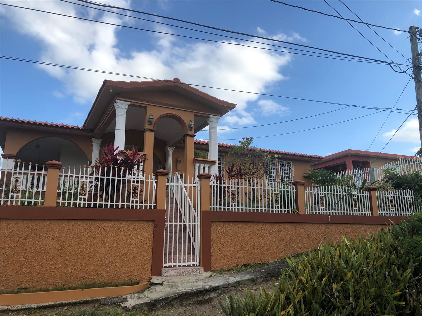 Private 5-Bedroom Home, Furnished in - Yauco, PR 
Nestled in the serene community of Almacigo Bajo in Yauco, this unique home property offers space, privacy, and flexibility - ideal for multigenerational living. 
The home, custom-built by the current and only owner, features 5 spacious bedrooms, each with its own generously sized closet, and 2 full bathrooms. Constructed in 1979 and expanded in 2003, it showcases thoughtful design, quality masonry construction, and has withstood multiple major hurricanes with resilience. 
Enjoy cooking in the freshly painted kitchen, which includes a brand-new stove, an abundance of cabinets, and a layout designed for ease. The home also includes a large living room and a separate dining room, perfect for gatherings. It is being sold fully furnished, offering a move-in-ready opportunity or an ideal primary home, second residence or investment property. Step out onto the large balcony to relax, feel the breeze, and take in the beautiful views of the surrounding area. 
The gated property includes a private driveway, two garages (one for one car and another for two), and sits on a spacious lot with tropical touches like a mango tree and banana trees. 

The home also includes a separate entertainment/sitting area on the side of the house - perfect for family cookouts, relaxing outdoors, or hosting gatherings. The private driveway is extra-large and can comfortably accommodate up to 10 vehicles, providing ample parking for residents and guests alike.