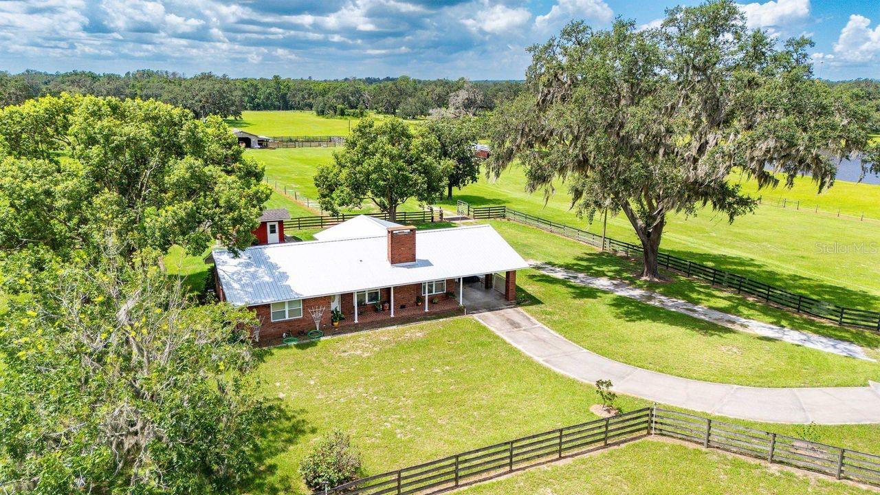 Welcome to 38730 Mickler Road in beautiful Dade City, Florida - a meticulously maintained 35-acre ranch property offering the perfect blend of functionality, privacy, and natural beauty.
This 1,900 sq ft ranch-style home sits at the end of a long, private driveway, tucked beneath grand, old oak trees and accessed through an electric gate. The spacious 2-bedroom, 2-bath layout features a warm and inviting farm-style kitchen with a breakfast bar, built-in oven, and ample space for preparing meals and entertaining. A newer metal roof adds durability and peace of mind, while thoughtful touches throughout reflect the pride of ownership.
Ideal for equestrian or agricultural use, the property is fully set up with five fenced paddocks, a barn and cow pens equipped with electric and hot water, and irrigation already in place for citrus trees or an expansive garden. A picturesque pond, stocked with catfish and brim, adds to the charm and usefulness of the land. There's even an air-conditioned 24x12 storage building offering flexible space for hobbies, an office, or private retreat.
This property is a dream for those seeking a homestead, horse farm, or working livestock operation...