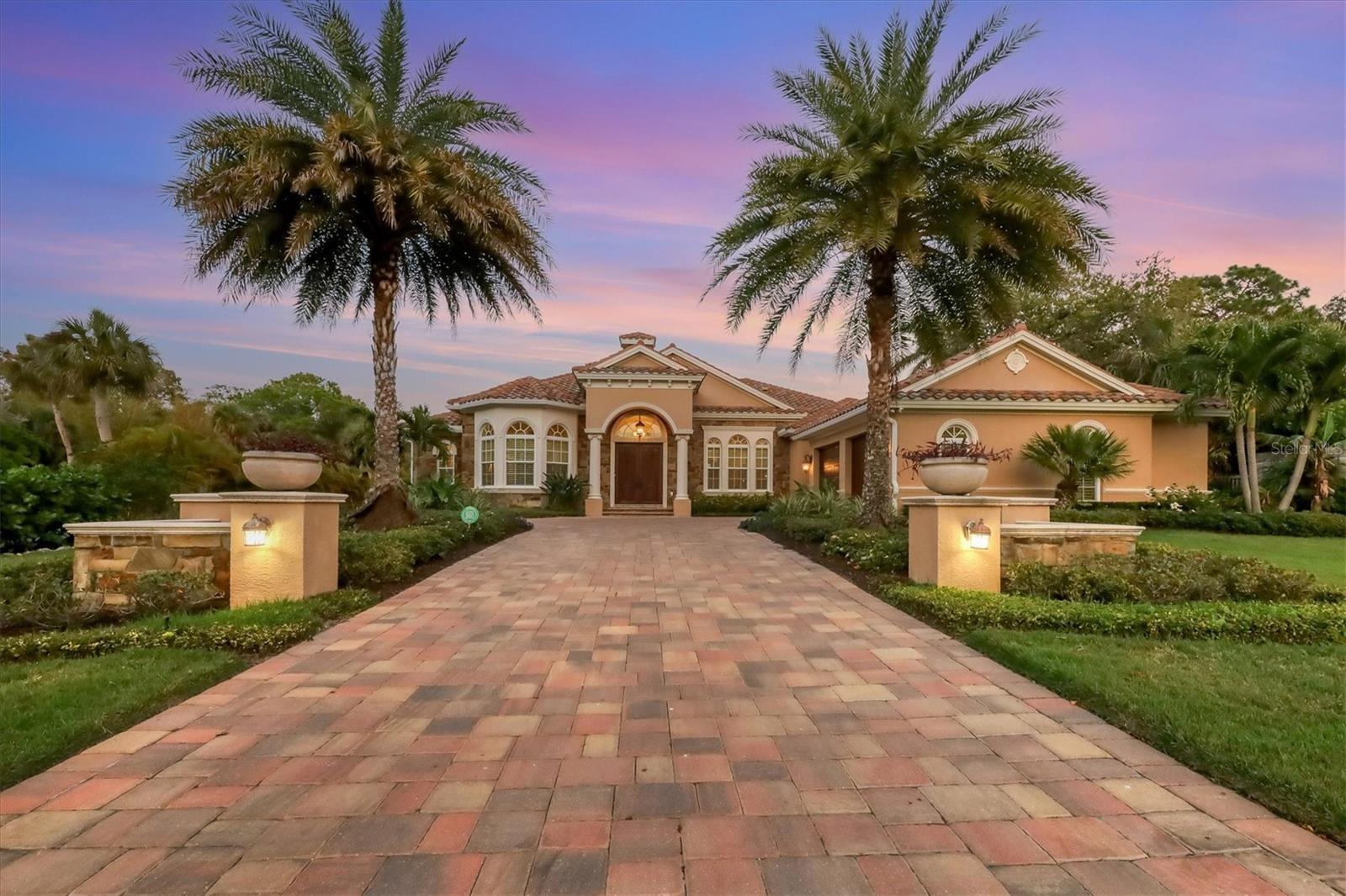 Located “West of Trail” in one of the most sought-after areas in Sarasota this stunning home is perfectly positioned on a corner lot amidst the lush Florida landscape to deliver the utmost privacy yet be minutes from everything living in Sarasota has to offer. Built in 2014 by well-known local builder, Todd Johnston, this home blends classic architectural elements and beautiful finishes to create a stunning, yet functional living space. The impressive room sizes, travertine tile floors, granite countertops, custom cabinetry, and huge banks of windows and doors are just some of the features that make this home special. The living room opens to outdoor living space and flows seamlessly to the adjacent dining room and kitchen creating an amazing entertaining space. The kitchen outfitted with beautiful wood cabinetry, granite countertops, stainless steel appliances, a bar area with a wine refrigerator, a pantry, and two large functional islands, will impress even the most discerning chef. The family room boasts corner sliding glass doors that open to the expansive covered outdoor kitchen, sitting area, and pool. The spa-like owner’s suite and office are situated on one side of the home, while the guest bedrooms are on the other side, resulting in the utmost privacy for family and guests. The lanai features a paver deck, a heated free-form pool with spa, a fireplace, and an outdoor kitchen with bar seating. A large functional laundry room, ample storage closets, a fenced side and back yard, and a sideload two-car garage complete this incredible residence. All this in an amazing location near The Field Club, Siesta Key, Southside Village, Sarasota Memorial Hospital, and Downtown Sarasota.