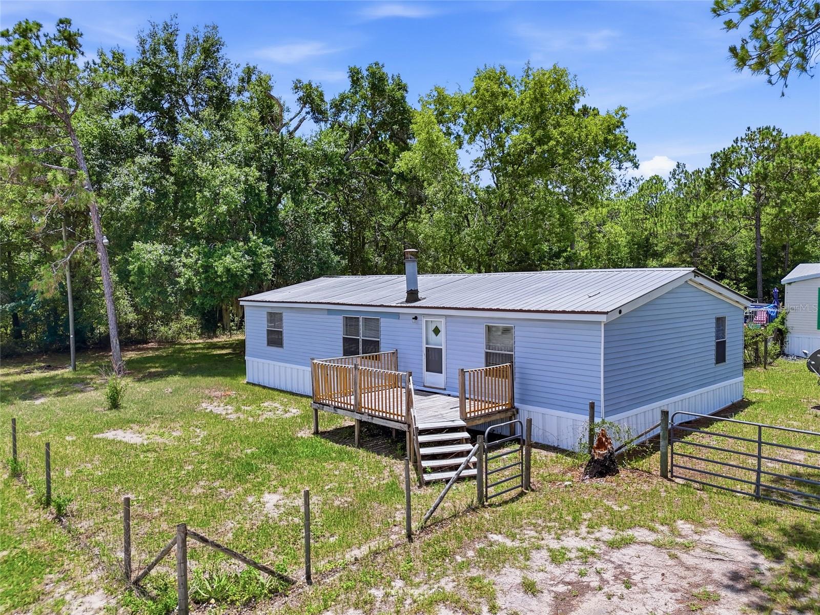Discover the potential at 350 Ishie Avenue in Bronson, Florida! This updated 3-bedroom, 2-bath manufactured home sits on a spacious corner lot in a convenient location just minutes from schools, parks, and downtown Bronson. Whether you're looking for a rental property, affordable primary residence, or addition to your investment portfolio, this property offers exceptional value and strong income potential.
Inside, you'll find numerous recent updates including luxury vinyl plank flooring throughout, fresh interior paint, updated bathrooms, and refreshed living spaces that create a bright, move-in-ready feel. The open-concept floor plan features a large living area, spacious kitchen with abundant cabinetry and counter space, and generously sized bedrooms. A wood-burning fireplace adds warmth and character to the main living area. Outside, the property offers ample yard space, room for parking, and easy access from a paved road. The corner lot location provides added privacy and flexibility for future use. Conveniently located across from local schools and athletic facilities, this property combines affordability, functionality, and investment appeal. Don't miss this opportunity to own an updated property with strong rental potential and room to grow!