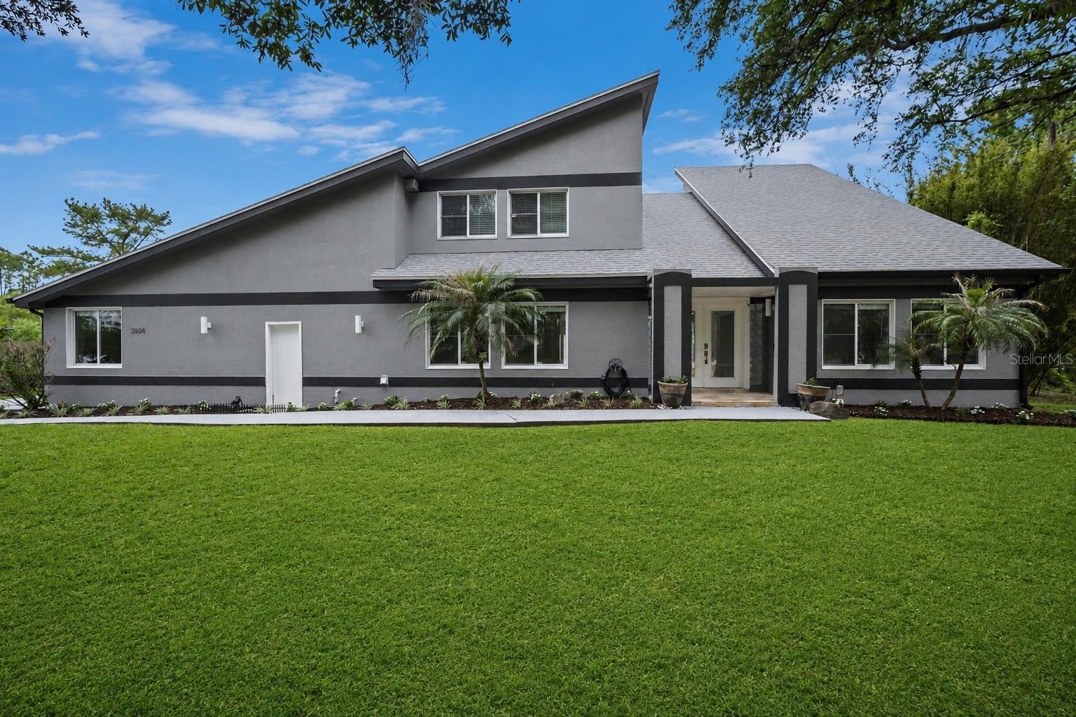 Tucked away in the charming, quiet community of Rambling Acres, this one of a kind custom estate sits on 1.24 acres and offers over 4,000 sq ft with 5 bedrooms, 3 full and 1 half bath. From the moment you walk in, you're welcomed by a stunning open air interior atrium with a koi and turtle pond, creating a true focal point enjoyed from multiple rooms. Designed for both everyday living and entertaining, the home features a 10 seat movie theater, spacious living areas filled with natural light, and a large primary suite with a beautiful en suite bath. Major updates include a 2022 roof, three HVAC units (2022), updated electrical and plumbing (2022), and a 2024 water heater. Step outside to your own private retreat with an updated concrete patio, plus a versatile outdoor space with power, lighting, a 30 amp camper hookup, and room for hobbies, toys, or even a future pool. This is the kind of home that truly stands out. Conveniently located near Kennedy Space Center, SpaceX and Blue Origin. Just a short drive to the beautiful Space Coast beaches, this home offers the perfect balance of peaceful living and easy access to everything the Space Coast has to offer.