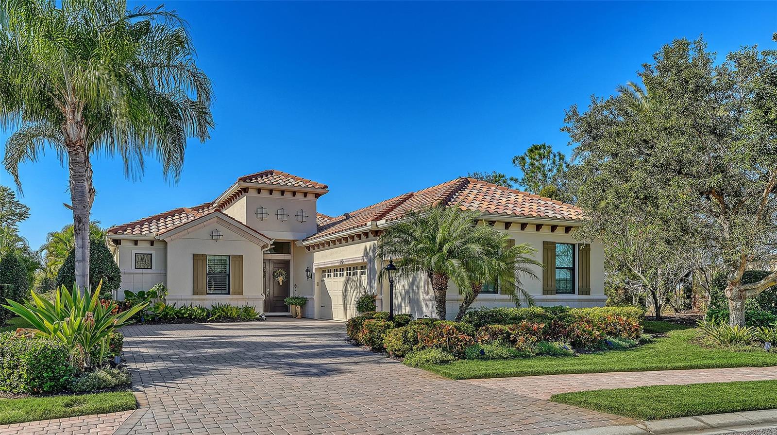 Privately positioned on an oversized homesite within the gated enclave of Country Club East, this beautifully appointed three-bedroom, 3.5-bath residence with a private office enjoys tranquil preserve views that create a serene, park-like backdrop for everyday living. The setting offers a rare sense of space and privacy while embracing the best of Florida’s indoor-outdoor lifestyle.
A welcoming entry through double front doors introduces a light-filled interior where a private office with double doors sits just off the foyer. The open great room is designed for both comfort and entertaining, highlighted by soaring ceilings, tray accents, and a sleek wet bar with stone countertop. Large sliding glass doors frame peaceful preserve views and lead seamlessly to the lanai beyond.

The chef’s kitchen is thoughtfully designed with rich wood cabinetry, stone countertops, stainless steel appliances, upgraded lighting, and a generous island with breakfast bar. A built-in desk tucked beside a picture window provides a charming workspace with views of the surrounding greenery, while the formal dining area with crown molding and designer lighting sets the stage for memorable gatherings.

The primary suite is a true retreat, featuring luxury vinyl plank flooring, plantation shutters, a tray ceiling, and two walk-in closets. The spa-inspired bath offers split vanities, a beautifully tiled walk-in shower, and a private water closet. Two additional guest suites, each with its own bath, are positioned at the front of the home to ensure privacy for family and guests.

Outdoor living takes center stage on the expansive lanai with a heated pool and spa, dedicated pool bath, and breathtaking sunset views over the preserve—ideal for relaxing or entertaining. Notable upgrades include a side-entry three -car garage, enhanced landscaping, a Culligan whole-house water system, sealed attic for energy efficiency, six wall mounted televisions and more.

Residents of Country Club East enjoy gated security, scenic walking trails, a fitness center, and multiple community pools, along with exclusive access to The Retreat and The Residents Club offering resort-style amenities, dining, and social spaces. Optional membership to Lakewood Ranch Golf & Country Club provides access to championship golf, tennis, pickleball, state-of-the-art fitness facilities, and multiple clubhouses.