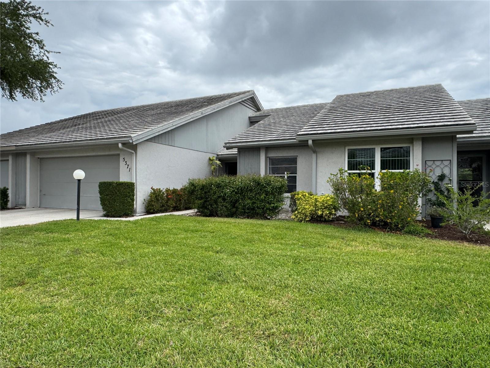 This beautifully updated villa in the desirable Crestwood Villas community offers the rare combination of tranquil lake views and modern comforts, all just steps from the community pool. The bright, open floor plan features soaring vaulted ceilings that flow seamlessly into a spacious enclosed lanai overlooking the peaceful lake. Tile flooring throughout ensures easy maintenance, while the updated kitchen shines with granite counters, fresh cabinetry and appliances, and a generous granite breakfast bar—perfect for casual meals or entertaining.
The primary suite is a true retreat, boasting calming lake views, dual walk-in closets, and a luxurious bath with a tiled shower and ample vanity space. A second updated full bath with tile finishes completes the home. Located near Honore Avenue and Wilkinson Road, this villa provides effortless access to everything Sarasota has to offer—world-class beaches, shopping, dining, and the vibrant arts scene. This is a rare opportunity to own a lakefront villa in a prime location. Ideal for those seeking both relaxation and convenience in one of Sarasota’s most convenient communities.