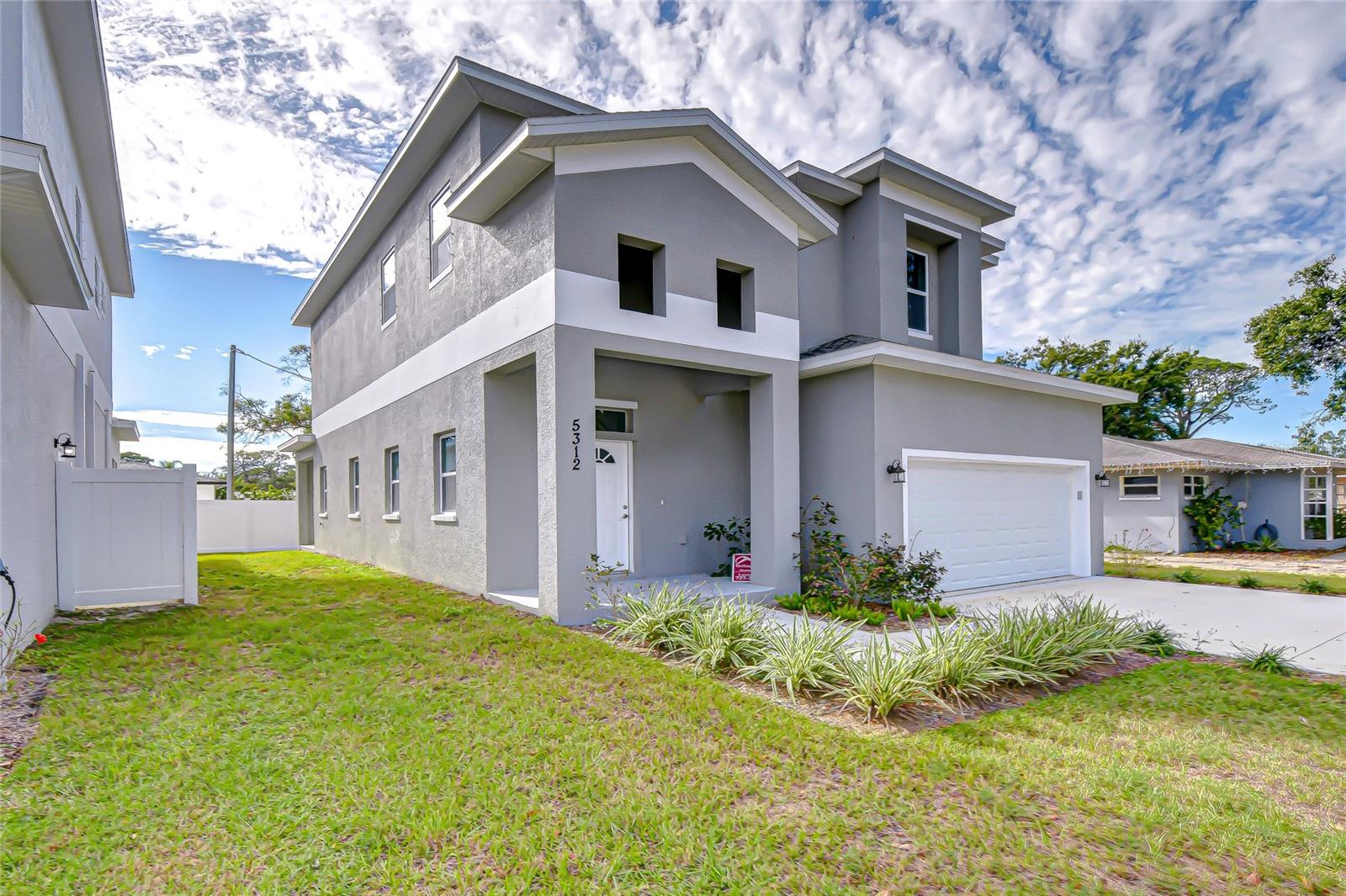 One or more photo(s) has been virtually staged.  Welcome to your brand-new home in the heart of South Pinellas County. This modern, thoughtfully designed residence features a bright white kitchen with sleek solid-surface counters, beautifully crafted ceramic tile flooring, and a spacious layout perfect for everyday living and entertaining. The kitchen boasts a large granite prep island with space for barstools, plus a cozy breakfast nook ideal for casual meals. The family room impresses with soaring ceilings and convenient storage tucked under the stairs. Upstairs, durable and stylish luxury vinyl plank flooring flows throughout, creating a clean and cohesive look. All bedrooms are generously sized and include walk-in closets, while the oversized laundry room—with its own utility sink—adds extra functionality to this perfect layout. NEW SCREENED LANAI added this week.  Situated just a short drive from Florida’s world-renowned beaches and only 20 minutes to Tampa International Airport, this home offers unmatched convenience. Enjoy top-notch dining, shopping, and entertainment options right nearby. Discover the ideal blend of comfort, style, and location.  Finishes on both homes (5312 and5302) are similar - tour specific home to see exact finishes for this beautiful property