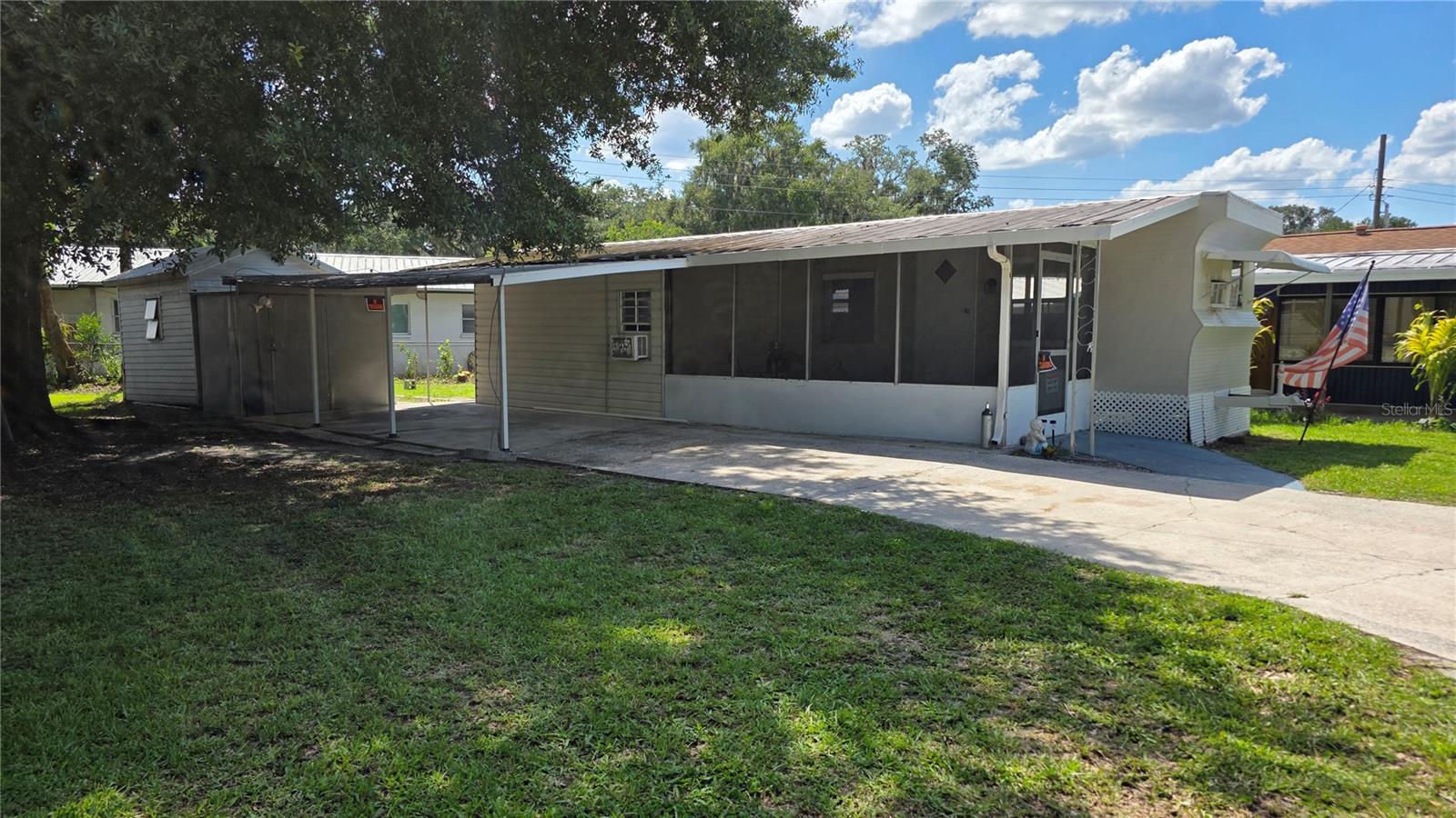 Affordable Florida living with no HOA and you own the land! This charming and well-maintained 2-bedroom, 1-bath single-wide mobile home offers 560 square feet of comfortable living space in a convenient Lakeland location close to shopping, restaurants, medical facilities, and everyday conveniences. Don't let the age fool you—this home has been lovingly cared for and tastefully updated while maintaining its unique character. Inside, you'll find easy-care tile flooring throughout, a cozy primary bedroom with warm nautical-inspired wood accents, and an updated bathroom featuring a tiled tub/shower surround and pedestal sink. The bright kitchen and living spaces create a welcoming atmosphere that's perfect for year-round living or a seasonal Florida retreat. Enjoy your morning coffee on the screened front porch, and take advantage of the covered carport with extended tandem parking. Two exterior storage sheds provide plenty of room for tools and hobbies, with one housing the laundry area for added convenience. Additional updates include a roof in 2018, septic pumped in 2024, and window A/C units that will convey with the home. Whether you're a first-time buyer, snowbird, investor, or simply looking for an affordable place to call home, this clean, cozy, move-in-ready property is a fantastic opportunity. Cash Sale only, due to age of home. Schedule your private showing today!
