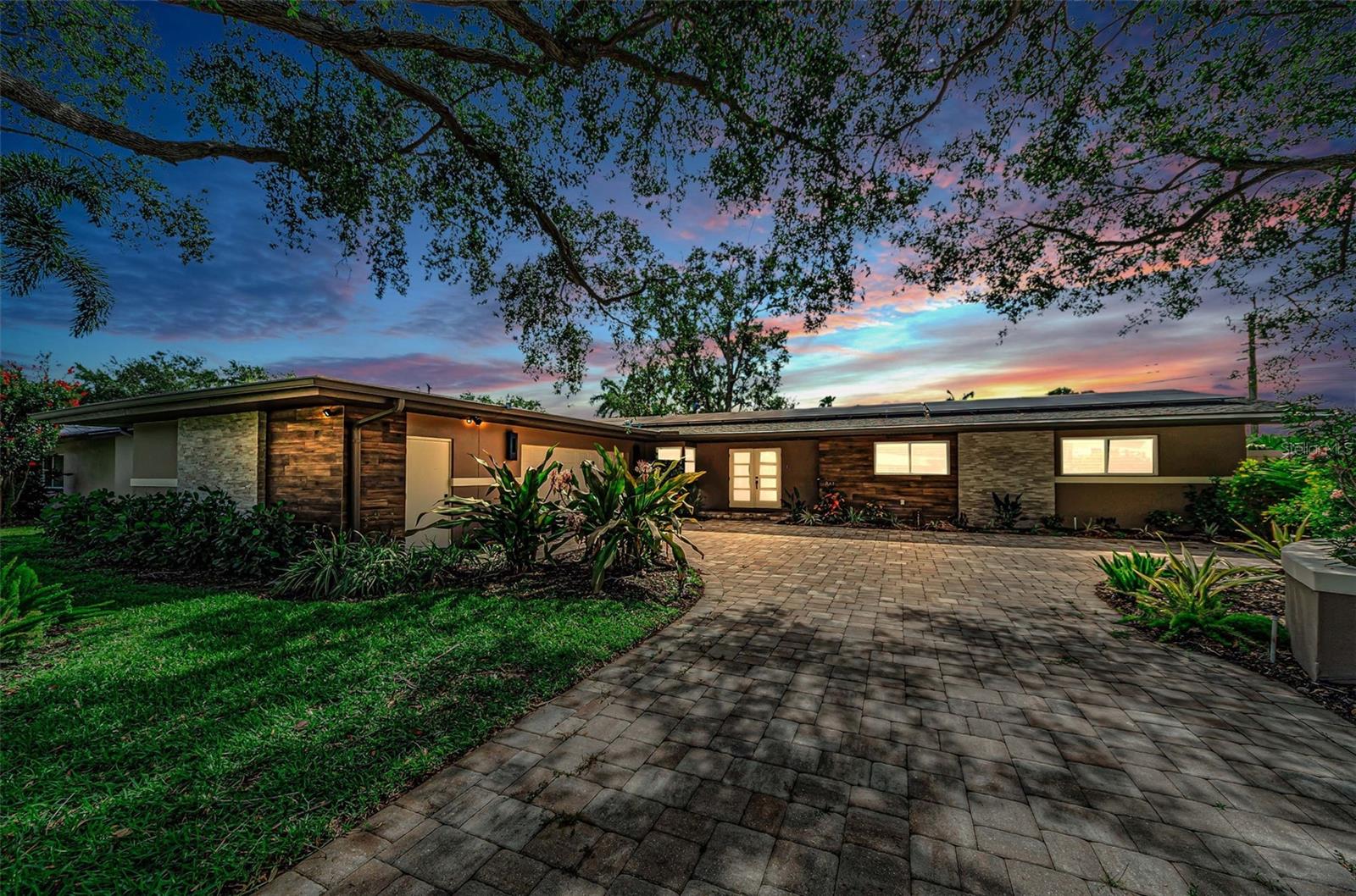 GORGEOUS CONTEMPORARY COSMOPOLITAN CHIC IN AN EXCEPTIONAL SNELL ISLE LOCATION.  A distinguished brick paver driveway introduces a uniquely-beautiful faux wood porcelain and tumbled marble exterior façade.  The welcoming covered double door entry opens to a dazzling great room plan with views of the rear courtyard and swimming pool.  Great room delivers a suave, sophisticated appeal with fine wide-plank oak wood flooring and a distinctive custom beamed ceiling.  The resplendent kitchen is a flawless example of art following form and function: elegant quartz surfaces with quartz backsplash complement modern cabinetry and high-quality stainless-steel appliances including a superb Forno Paola range with Wolf range hood, and large built-in refrigeration.  A luxury island bar/serving center with waterfall counters provides seating for four.  You’ll love the matching butler’s pantry with its dedicated coffee station featuring a fantastic De'Longhi Magnifica espresso machine, seating area, generous storage and beverage chiller - a great place to start your day.  For those who enjoy the finer vintages, you’ll be delighted with the impressive 8 x 8 custom-built walk-in wine cellar with commercial-grade cooling and dehumidification.  The posh owner’s suite opens to the private pool deck and boasts a huge walk-in closet area with built-in island dresser.  The owner’s bath offers two lavish quartz vanities, and an amazing and beautifully-tiled walk-in double rain-shower with dual body wands.  The second bedroom is oversized and is supported by an exquisitely-appointed adjacent bath that doubles as the pool bath.  The sizable third bedroom sits across from a lovely full guest bath with minimalistic quartz vanity and rich tilework.  Step out back to the private garden and swimming pool sanctuary and feel life’s stresses just melt away.  A white shellstone paver deck encases a stunning Pebbletec saltwater pool and oversized spa.  Behind the pool rests a tumble marble half wall securing an attractive layered landscape.  The entire back yard is encapsulated within tall concrete walls offset by landscaping that delivers a private, oasis-like feel.  Fully operational solar panels assure this home has very low electric energy costs.  In addition to the oversized 2-car garage, you’ll appreciate the large dedicated storage area ideal for a golf cart and bicycles, or even a fitness area. Ideally located close to highly rated schools, just a few blocks from the Vinoy Golf and Country Club, and a short distance to downtown St. Petersburg.  A terrific luxury value in a great location!  Measurements are estimates, buyer to verify.