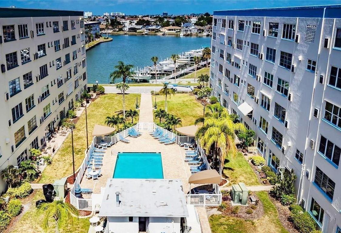 NEW $5,000 BUYER CLOSING CREDIT!! Don’t miss out on this LIGHT, BRIGHT AND MODERN UNIT with sleek European style in the Kenmore building at Town Shores of Gulfport ... a premier 55+ community with resort-style amenities! Priced to sell quickly, this charming unit is being offered FULLY FURNISHED AND TURNKEY to make it perfect either for a vacation getaway or your permanent forever home. The Kenmore is one of only two buildings at Town Shores with a secure lobby for extra safety and peace of mind. The building also withstood the previous storms with no damage or water intrusion.
You will appreciate the roomy open floor plan (1,120 sq ft) with two spacious bedrooms, two full baths and a pleasant and comfortable sunroom with views of one of the four heated pools in the community … plus, a large storage closet that can even fit a bicycle! The floor plan features a primary bedroom with an ensuite bath, window to the sunroom and double built-in closets for extra storage, plus a guest room with a dedicated hall bath. This well cared for unit emits a sense of style and design flair with neutral wall tones, flooring, newer light textured carpet, LIGHT WOOD TONE IKEA FURNITURE … all which convey with the unit. Other unit features and highlights include a newer HVAC (2023), a deeded carport (#53) and is conveniently located on the same floor with the laundry, just steps away from the elevator. The monthly HOA fee includes a Spectrum Bulk internet and wireless package, natural gas for cooking and hot water, flood and building insurance, and pool, landscaping and exterior maintenance. 
Town Shores has its own private marina and slips (as they become available), 4 heated pools, an active Clubhouse with weekly social events, a tennis/pickleball court, shuffleboard, bocce ball and kayak storage. This vibrant community is just a short distance from the fun, active and artsy village of Gulfport and its famous Tuesday Fresh Market and lively First Friday Art Walks. You are also just blocks away from the Gulfport public beach, restaurants, quaint inns, cafes, art galleries and boutiques! Town Shores is conveniently located just 30 minutes from Tampa International Airport and is a short drive to the cultural mecca of downtown St. Pete and the award-winning Gulf coast beaches. Schedule a showing today for this upbeat and modern unit around the corner from Gulfport Village!