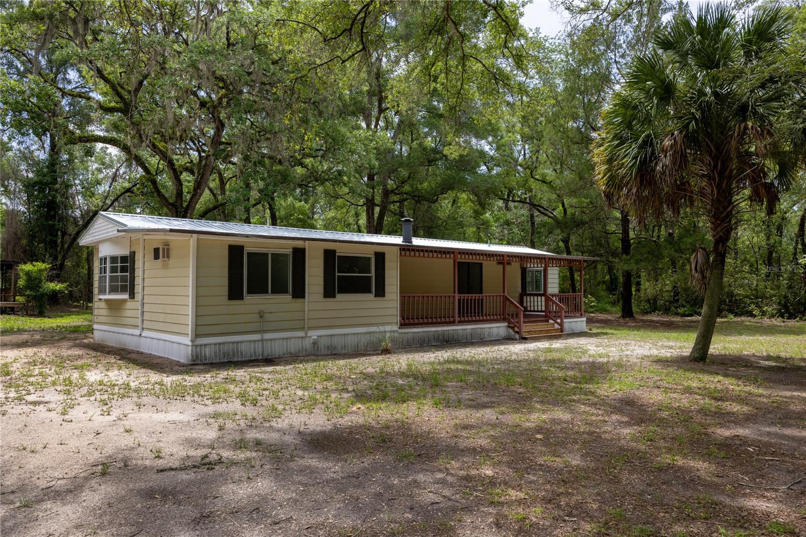 Welcome to this beautifully remodeled 2 bedroom 2 bathroom home situated on 2.19 wooded acres just minutes from the crystal-clear waters of Rum Island Spring. Nestled in the tranquil neighborhood of Rum Island, this serene location offers peace and privacy, making it an ideal spot to settle down and create your own haven. The home was fully remodeled in 2026 with high-end materials and craftsmanship. Step inside to discover a thoughtfully designed layout featuring a spacious living room perfect for both entertaining and relaxing, accented by natural light pouring in through windows. The kitchen features new stainless-steel appliances and ample cabinet storage. Adjacent to the kitchen, a laundry room with plenty of room for a washer, dryer, and extra storage racks. The primary bedroom is spacious and features a versatile bonus room, ideal for a home office. The primary bathroom has been tastefully remodeled with a new vanity and luxury vinyl flooring. This home has a split floor plan, providing a living room and dining room perfect for entertaining and relaxing. On the other side of the home, there is an additional bedroom and a fully remodeled bathroom, providing ample accommodation and closet space. Numerous updates have been made in the last few years, including a full house remodel in 2026: new interior paint, exterior vinyl skirting, new vinyl flooring and trim, new fans, stainless steel appliances, both bathrooms fully remodeled, a new metal roof in 2026, a 2022 AC unit, and a 2019 water heater. Outside, revel in the beauty of a fully fenced 2.19-acre property with a repainted back deck and storage shed. The property is mostly cleared land with some trees for added privacy. A spacious covered front deck creates a warm welcome, while the large screened back porch offers a relaxing, year-round retreat to enjoy the surrounding landscape. The property is richly wooded with mature trees, blooming azaleas, and dogwoods, creating a serene, park-like setting. A cleared area provides space for gardening, chickens, or small homesteading projects. Additional features include a large workshop/storage building with a new covered deck perfect for tools, equipment, hobbies, or extra storage. The property also features a gated entrance for added privacy and security. Located just minutes from Rum Island Spring and the Santa Fe River boat ramp, this property is ideally positioned for outdoor recreation. Enjoy nearby kayaking, tubing, and river exploration, making it an excellent opportunity for investors seeking a vacation rental or Airbnb in a popular springs destination. At the same time, the peaceful setting makes it equally appealing as a full-time residence or weekend getaway. With lower Columbia County taxes, a private setting, and easy river access, this property offers both lifestyle appeal and strong investment potential in one of North Florida's most scenic areas. The property is conveniently located just 9 minutes from downtown Fort White and 30 minutes from Gainesville, which offers ample options for dining, shopping, and hospitals. This is a one-of-a-kind property, so call today to schedule a showing!