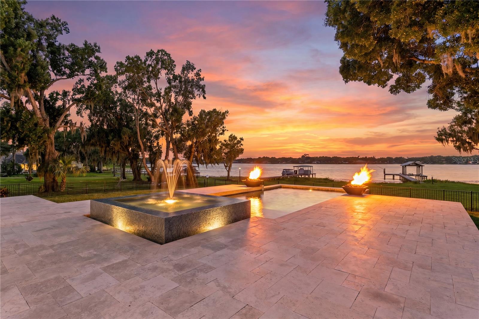 Nestled behind private gates on more than an acre along the shores of Lake Magdalene, this custom waterfront estate offers an exceptional blend of luxury, privacy, and breathtaking lake views. Thoughtfully designed to capture the beauty of the water from nearly every room, the residence showcases refined finishes and seamless indoor-outdoor living.

The expansive floor plan features 12-foot ceilings on the first floor and an open-concept layout that seamlessly connects the living room, dining area, and kitchen. Designed for both everyday living and entertaining, the kitchen includes breakfast bar seating and a casual dining area, all positioned to take advantage of stunning lake views. The second floor features a versatile loft, a luxurious primary bedroom retreat, and two generous secondary bedrooms, each with an en suite bath and custom walk-in closet. Pella windows and doors frame spectacular waterfront vistas while filling the home with natural light.

At the heart of the home, spacious living and entertaining areas flow effortlessly to the outdoor oasis. The resort-style pool is highlighted by elegant fire bowls, creating a private retreat for relaxation and entertaining. A separate pool bath adds convenience for guests.

Boating enthusiasts will appreciate the private dock and boat lift, offering direct access to Lake Magdalene’s approximately 206 acres of recreational waters, perfect for boating, fishing, paddleboarding, and sunset cruises. An oversized circular driveway provides abundant parking, while additional access allows for easy boat transport to the water. The attached two-car garage adds further convenience.

Rarely does a property combine such a premier lakefront setting with expansive acreage while remaining just minutes from Tampa’s finest dining, shopping, and entertainment. Experience waterfront living at its finest on one of Lake Magdalene’s most desirable properties.