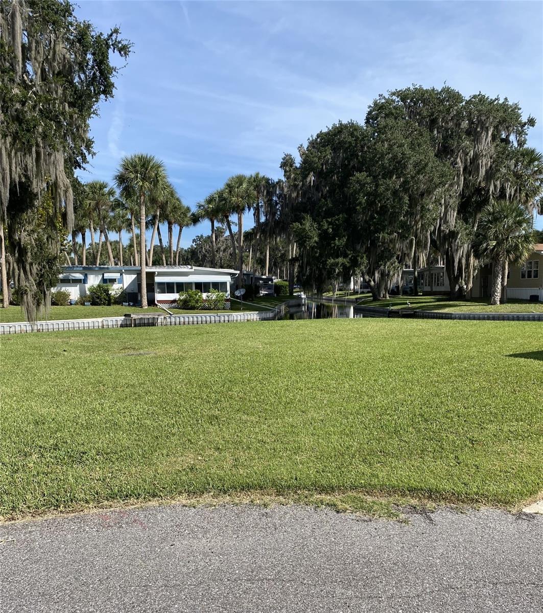 This lot is located in Country Club Manor, a 55 + Community on Trout Lake. The lot is ready to put a mobile home on it with no impact fee. The sale of the property includes the co-op share. The lot sits right on the canal with great views of the Water. The Club house and boat ramp are just steps away. The Co-op offers a lot of amenities for $243.00 a month which includes a heated community pool, shuffle board, recreational facilities, sewer, trash, water, and a private boat ramp. The community features a beautiful Clubhouse with a Variety of Activities which include Bingo, Special Occasion Events for Holidays, Pot Luck Dinners, and a ton of other activities. Please note although the property is in Lake county, the governing building permits are in the City of Eustis. Please contact the City of Eustis Building Department and the Country Club Manor office for any questions or concerns of size and placement of potential mobile home. No pets allowed in the community.