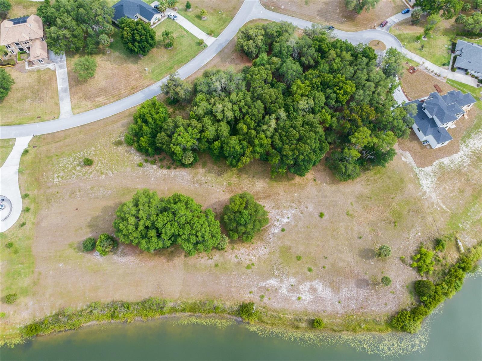 Look no further than this amazing opportunity to build from the ground up on this waterfront lot in the Black Bear community! Building your dream home just became a lot easier with this prime golf course community lot in the estates section offering custom homes, boasting 150 feet of lakefront access suitable for a dock, and featuring a gently sloped 1.56-acre lot. Adorned with majestic live oak trees and complemented by palm trees, this lot creates a serene and picturesque setting. Black Bear offers great amenities including golf, tennis, a playground, and so much more! Drive by this blank canvas to see what could be yours!