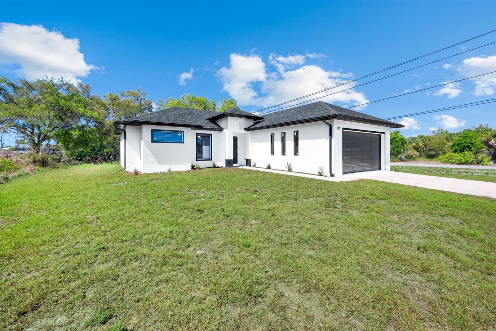 Contemporary design, open space, and everyday comfort come together in this beautifully built new construction home located in the growing community of Lehigh Acres. Offering 3 bedrooms and 2 bathrooms, this home delivers the perfect layout for modern living. From the moment you arrive, the sleek modern exterior and clean architectural lines create standout curb appeal. Inside, you’re welcomed by a bright open-concept living space filled with natural light, enhanced by glossy tile flooring and elegant tray ceiling details that elevate the entire space. The kitchen is both stylish and functional, featuring modern shaker cabinetry with crown molding, solid surface countertops, stainless steel appliances, and a spacious center island that becomes the heart of the home—perfect for entertaining or everyday living. Sliding glass doors lead to a covered lanai, seamlessly extending your living space outdoors. Whether it’s relaxing evenings or weekend gatherings, the backyard offers endless potential to create your own private oasis. The primary suite provides a peaceful retreat with dual sinks, modern finishes, and a spacious walk-in shower. Two additional bedrooms offers flexibility for family, guests, or a home office. Ideally located near major roadways, shopping, dining, schools, and Southwest Florida International Airport, this home offers both convenience and long-term value in one of Lehigh Acres’ fastest-growing areas. Move-in ready and designed to impress—this is the opportunity buyers have been waiting for.