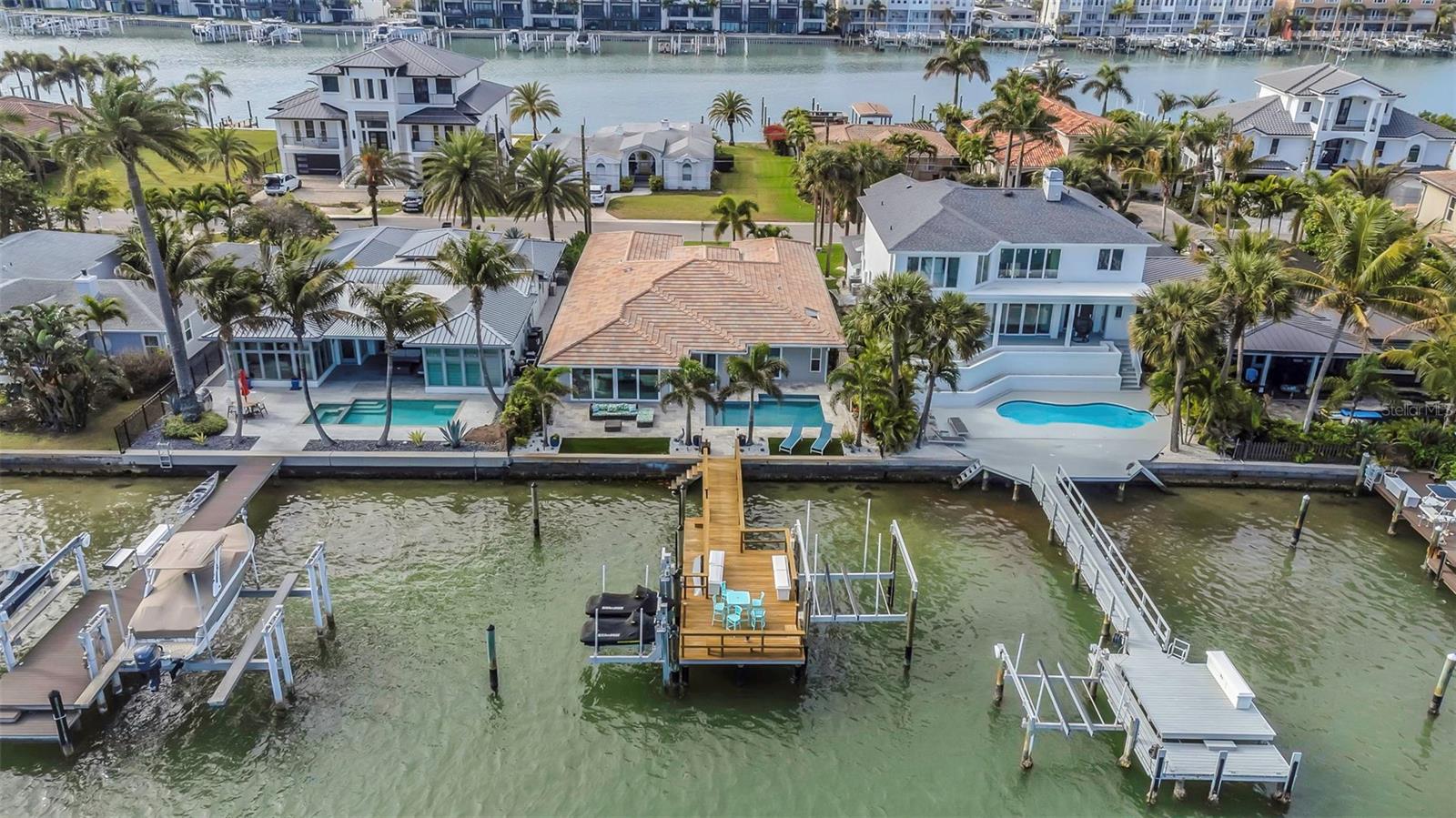 Discover your slice of paradise at 150 Devon Drive, where luxury meets the laid-back, sun-soaked Florida lifestyle.  This meticulously remodeled 4-bedroom, 3.5-bathroom home, including a convenient half bath accessible from the pool area, offers an elegant sanctuary on Clearwater Bay's serene intracoastal waterway. With 3,050 sqft of elegant living space, this home is a haven of sophistication and comfort, offering you a slice of paradise with every sunrise and sunset.
Step into a world where every detail caters to an upscale yet relaxed way of life. The heart of the home is a beautifully updated kitchen, boasting granite countertops, stainless appliances, and a bespoke coffee/wine bar with an Avallon wine cooler, perfect for entertaining or quiet mornings alike. Floor-to-ceiling glass sliding doors illuminate the home, offering breathtaking views and blending the outdoor oasis with the luxurious interior.
Your backyard is an entertainers' dream, featuring a newly enhanced Caribbean blue Pebble Tec pool, complete with a state-of-the-art pool heater for year-round enjoyment. The newly updated private dock, boasting a 13,000 lb boat lift, kayak launch, and dual jetski lifts, invites endless water adventures or tranquil evenings watching the sunset.
Inside, modern touches like California Closets, stylish shutters and electronic blinds with remotes elevate the space, blending effortlessly with the home’s chic, Florida-inspired aesthetic. Not only that, but the garage has been transformed into a versatile space with upgraded storage solutions, ensuring every inch of this home is as functional as it is beautiful.
The allure of this property extends beyond its doors, with its prime location offering walkability to a variety of local restaurants, embodying the ease and charm of Florida living. Whether you're in the mood for a casual beachfront cafe or a fine dining experience, everything is just a stroll away. 
Located just a short walk or bike ride to the world-renowned sugar sands of Clearwater Beach, this property promises a lifestyle filled with sandy beaches, watersports, and leisurely promenade strolls where every day feels like a vacation.