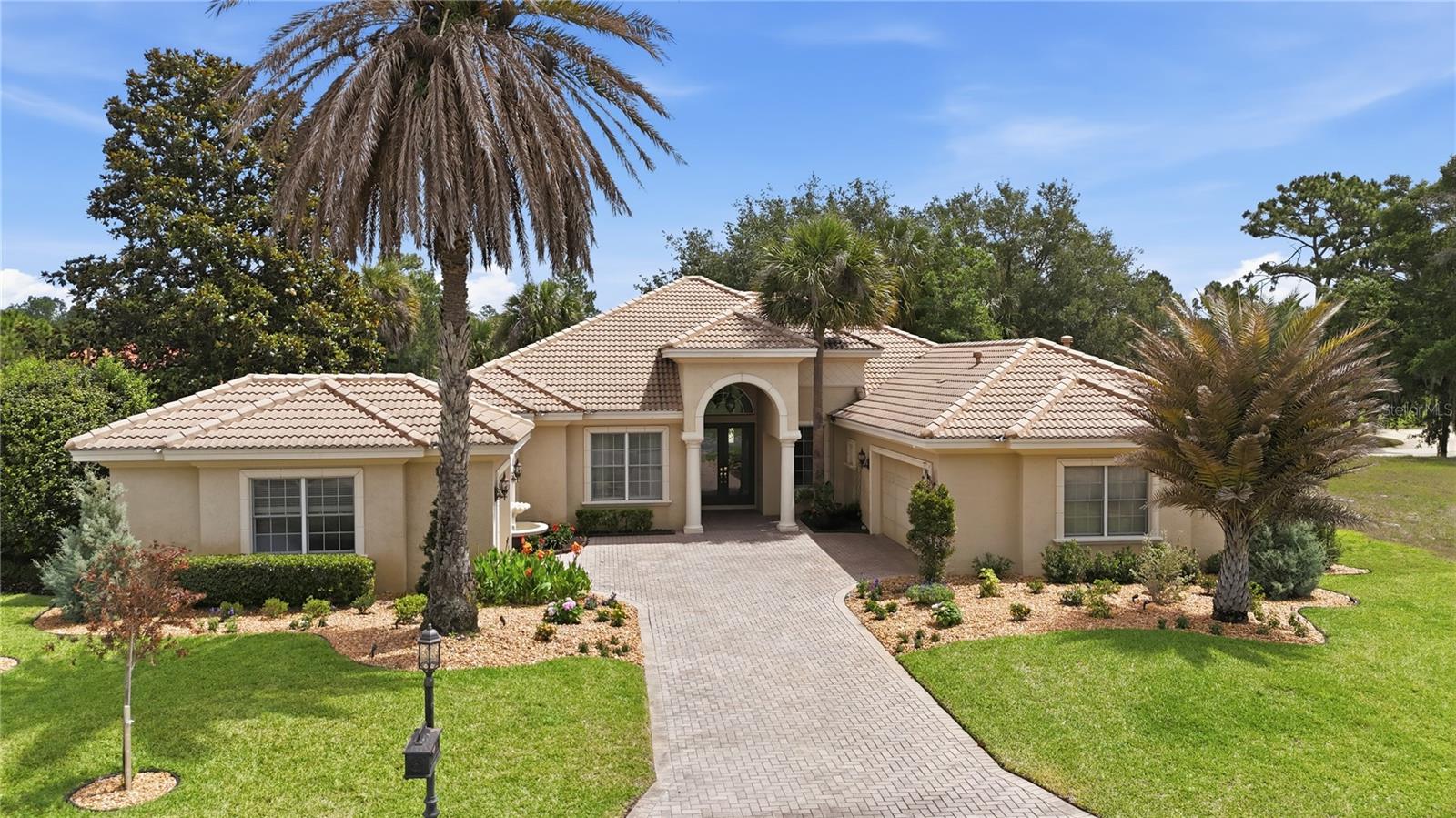 Welcome to luxury living in the desirable gated golf community of Juliette Falls in Dunnellon, Florida — ideally located near the World Equestrian Center, Rainbow River, and Ocala’s growing equestrian and outdoor lifestyle destinations. While golf enthusiasts will appreciate Juliette Falls’ nationally recognized championship course, this home also offers the perfect blend of privacy, flexibility, and resort-style living for full-time residents, equestrian enthusiasts, remote professionals, and seasonal homeowners alike.

Perfectly positioned on the Par 5 11th hole, this exceptional custom Mediterranean/contemporary ranch-style home offers panoramic golf course views and nearly 3,000 square feet of beautifully designed living space. Meticulously maintained, the home features 4 bedrooms plus an office, 3 full baths, and upscale finishes throughout.

Concrete block and stucco construction combine with a desirable split-bedroom floor plan, soaring tray ceilings, porcelain tile flooring in the main living areas, abundant natural light, and a gourmet kitchen complete with gas stove, custom cabinetry, built-in appliances, and generous prep space ideal for entertaining.
The luxurious primary suite provides a private retreat with spa-style bath accommodations with two large walk-in closets and direct access to the outdoor living area. All guest bedrooms feature carpeting for added comfort. The fourth guest bedroom suite includes a walk-in closet with custom built-ins,  and offers exceptional flexibility with its own private exterior entrance and full bath — ideal for an in-law suite, live-in arrangement, private guest quarters, or work-from-home setup.

Additional interior highlights include a spacious mud room/laundry area with extensive cabinetry and storage, smart home features, and dual internet connectivity with both cable and Starlink service installed for dependable, uninterrupted high-speed internet access — a major advantage for remote work and streaming.
Step outside to your private Florida oasis overlooking the fairway, featuring a screened lanai, sparkling heated pool, spa, extensive brick paver decking, custom fire pit area, and breathtaking panoramic golf course views — ideal for relaxing or entertaining year-round.
A standout feature of the property is the oversized split 3-car garage configuration, including a separate third-car garage currently outfitted as a fully equipped private gym, offering incredible flexibility for fitness, hobbies, golf cart storage, workshop space, or additional vehicle storage.
Recent owner improvements include:
• Whole-home generator
• New pool pump and electronics
• New pool heater
• Hard-wired security camera system
• New AC compressor
• New water purification system
• New lanai screens
• Upgraded landscaping and lawn
• Wi-Fi-controlled remote irrigation system programmable from anywhere
• Starlink installation
• Custom fire pit area
Additional highlights include:
• Premium golf frontage with sweeping panoramic views
• Concrete tile roof
• Mature landscaping and masonry features
• Private gated community setting
• Close proximity to WEC, Rainbow River, dining, shopping, and outdoor recreation
Residents of Juliette Falls enjoy a beautifully maintained gated community with championship golf, clubhouse dining, walking trails, and private roads. 
Experience the perfect blend of elegance, comfort, flexibility, and Florida lifestyle living. Schedule your private showing today!