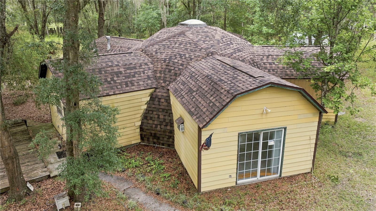 One-of-a-kind geodesic/dome-inspired home on 5 private acres – a rare opportunity to create something extraordinary! Your horse farm, personal retreat or multi-generational homestead.  If you've been searching for a property that's anything but ordinary, this custom owner-built home is ready for its next chapter. Situated on 5 private A-1 zoned acres (no HOA) on a flag lot just off Hwy. 225 in Reddick, this unique 2-bedroom, 1-bath residence features a striking geodesic/dome-inspired design with soaring vaulted ceilings, a dramatic central skylight, and an expansive open living area that creates an impressive sense of space and natural light. Built with 2x6 wood stud construction for added strength and durability, the home offers a solid foundation for your vision. A brand-new roof (2026) is already in place, giving the next owner the rare opportunity to personalize the finishes and complete the home to their own taste and style. Whether you're looking for a distinctive primary residence, a weekend retreat, an artist's haven, or a truly unique homestead, the possibilities are endless. The beautiful 5-acre parcel provides plenty of room for horses, livestock, gardens, workshops, or simply enjoying the privacy and peaceful country setting. Country living while remaining conveniently close to Ocala, major highways, shopping, dining, and world-class equestrian events and training facilities.  17 miles to downtown Ocala,  12.8 miles to The world equestrian center, 8.4 miles to HITS.   This is more than just a home—it's a chance to own a one-of-a-kind architectural statement. If you have vision and appreciate homes with character, this could be the propety  you've been waiting for.