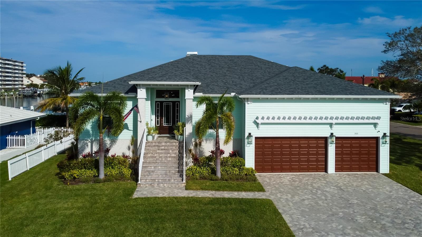 Live life on the Island in this 2021 custom built estate designed to stand the test of time.  Solid block construction, high elevation, impact rated windows and doors and professional landscaping offer elegant strength and peace of mind.  Nestled on a sprawling .28 acre corner lot in ever desirable Island Estates.  With gracious appointments and immaculate detail, this is a one of a kind home you immediately fall in love with.  Stepping inside you will find a spacious office to the left, which could serve as a fourth bedroom, and an equally large dining room to the right.  High end porcelain tile is laid throughout this open floorplan with split bedrooms ensuring privacy and functionality for all.  The Chefs kitchen is central to the home and is adorned with custom soft close cabinetry, Jenn-Air gas range, dual convection ovens, WiFi enabled GE Cafe refrigerator, breakfast bar, undermount lighting, and quartz countertops.  The kitchen opens to the living room with towering and coffered ceilings and is bathed in light from the sliders that lead you out the the lanai overlooking the Intracoastal.  The expansive lanai with built-in gas grill is the perfect place to entertain while gazing out at the serene water.  Retreat to your Master suite complete with an incredible walk-in closet with built-in cabinetry and resort worthy en-suite with walk in shower and quartz countertops.  An inside utility room and walk-in food pantry are just off the kitchen and lead you to your oversized three car garage with 20 foot ceilings and built-in storage.  Enjoy all the Island life has to offer with a short stroll to high end dining, grocery stores, marina with boat slips, and the renowned Clearwater Marine Aquarium just down the street!  Clearwater Beach is just around the corner with its robust shopping, restaurants, nightly festivals, and unparalleled gulf sunsets.  When its time to explore, take a walk up to secluded Caladesi Island or hop on the Jolly Trolley and enjoy the ride through quaint beach towns all the way down to bustling St Pete.  Close to international airports, champion caliber professional sports, exclusive golf courses, top level inshore and offshore fishing, and of course, world famous Gulf beaches.