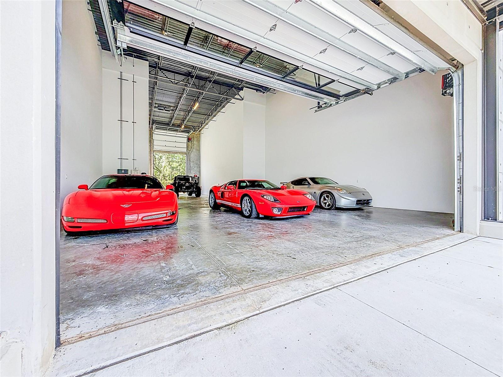 Imagine pulling your motorhome through the rear door while your sports cars stay exactly where you parked them.

That's the kind of functionality that makes Garage Condo #1103 one of the most unique opportunities at The Motor Enclave. Perfectly positioned with an 18' x 10' track-facing overhead door in front and a 16' x 9' RV-sized overhead door in the rear, this rare configuration was designed for enthusiasts who value convenience as much as horsepower. While true drive-through capability is certainly possible, the real advantage is everyday usability. Bring in your motorhome, stacker trailer, race car, or oversized toys from the rear without constantly moving collector cars, repositioning lifts, or jockeying vehicles around just to get one in or out.

Inside, approximately 2,296 square feet of open interior space stretches nearly 82 feet deep, creating an incredible blank canvas for the ultimate automotive retreat. With 24-foot ceilings, there's outstanding potential to add a mezzanine overlooking the garage below—perfect for a lounge, office, simulator room, or entertaining space.

One of the future highlights is the 138-square-foot front balcony, positioned on the track side and accessed from the mezzanine level. Imagine wrapping up a few laps, grabbing a drink, and stepping onto your private balcony to watch the next session from above. Protected by a 438-square-foot covered canopy, it's designed to become one of the best seats at The Motor Enclave.

The garage is already equipped with dual HVAC systems, multiple electrical services, a 30-amp RV outlet, Level 2 EV charging, additional 120/208V electrical capacity, water rough-ins, and fire suppression, giving the next owner the infrastructure to create a truly custom space.

Located on more than 200 gated acres at the I-75 and I-4 interchange, The Motor Enclave is the world's largest private garage community and one of the country's premier automotive destinations. Optional membership to the Motorsports Club provides access to the 1.72-mile Hermann Tilke-designed performance circuit, 2-acre skid pad, 100 acres of off-road trails, resort-style pool, and the impressive 37,000-square-foot Event Center, home to automotive launches, corporate functions, social gatherings, and an incredible community of fellow enthusiasts.

This isn't simply a place to store cars—it's where passion, performance, and community come together. Track-facing garages with a rear RV access door rarely become available. If you've been waiting for one of the most versatile and future-ready garages at The Motor Enclave, Garage Condo #1103 deserves your attention.