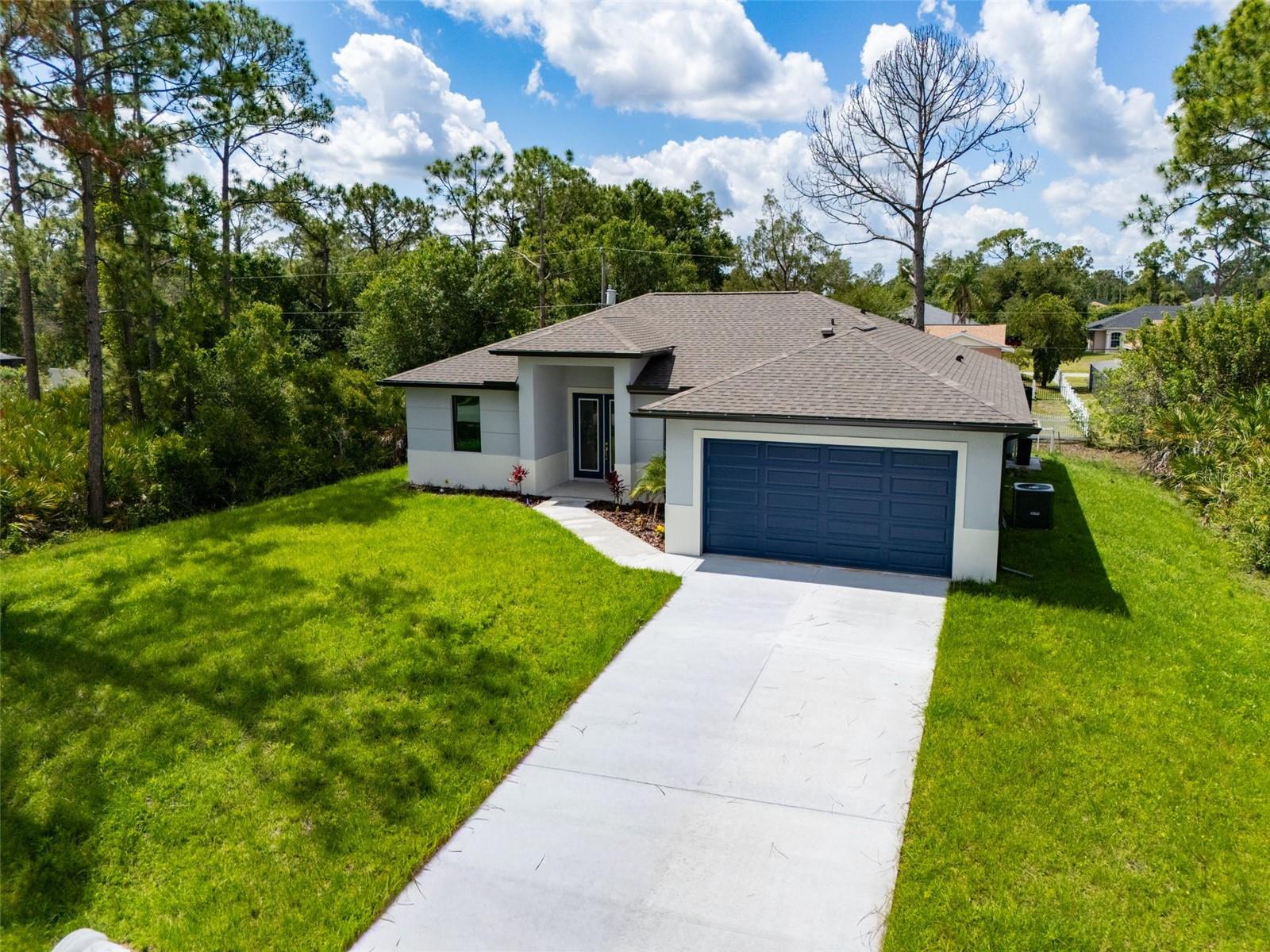 Welcome to a stunning example of modern luxury living in the highly desirable city of North Port. This brand-new 2026 fully custom-built MODEL HOME showcases exceptional craftsmanship, upscale finishes, and a thoughtfully designed layout that perfectly blends sophistication with everyday comfort. Spanning 1,650 square feet, this BEAUTIFUL 4-bedroom, 2-bathroom home features a bright open-concept floor plan highlighted by soaring 10’4” ceilings, elegant tray ceiling details, and oversized double glass entry doors that flood the interior with natural light. Throughout the home, impressive 48x48 porcelain tile flooring enhances the clean, contemporary aesthetic while creating a seamless flow from room to room. The designer kitchen serves as the centerpiece of the home, crafted to impress both visually and functionally. It features Level 4 quartz countertops with dramatic waterfall edges, full wood soft-close cabinetry, stylish pendant lighting, stainless steel appliances, a charming farmhouse sink, and decorative hardware accented with slick black trim, creating a space that feels both luxurious and welcoming. The expansive primary suite offers a true private retreat, complete with dual walk-in closets and a spa-inspired bathroom showcasing a floor-to-ceiling tiled shower with modern 64x12 tile, dual-sink vanity, and elegant designer mirrors and fixtures. Additional bedrooms are generously sized, while the fourth bedroom provides the perfect space for a home office, den, or flexible living area. Premium upgrades continue throughout the home and include: * Impact-rated front door and bronze impact windows * Electric fireplace * Whole-home water softener system * Full irrigation system * *Professional landscape package * Plus a worry free complimentary 10-YEAR HOME WARRANTY * Ideally situated in the growing community of North Port, the property offers convenient access to Interstate 75, HWY 41, the brand-new, soon-to-be-built state-of-the-art hospital, plus quick access to some of the area's finest shopping, dining, parks, schools, warm mineral springs and more. This exceptional new construction home combines modern luxury, high-end finishes, and a prime location—an outstanding opportunity to experience the very best of Florida living. So don't let your Florida dream home become someone else's address, set up your showing today! ** Be Sure To Check Out the Beautiful Fly Through Video of This Gorgeous Home **