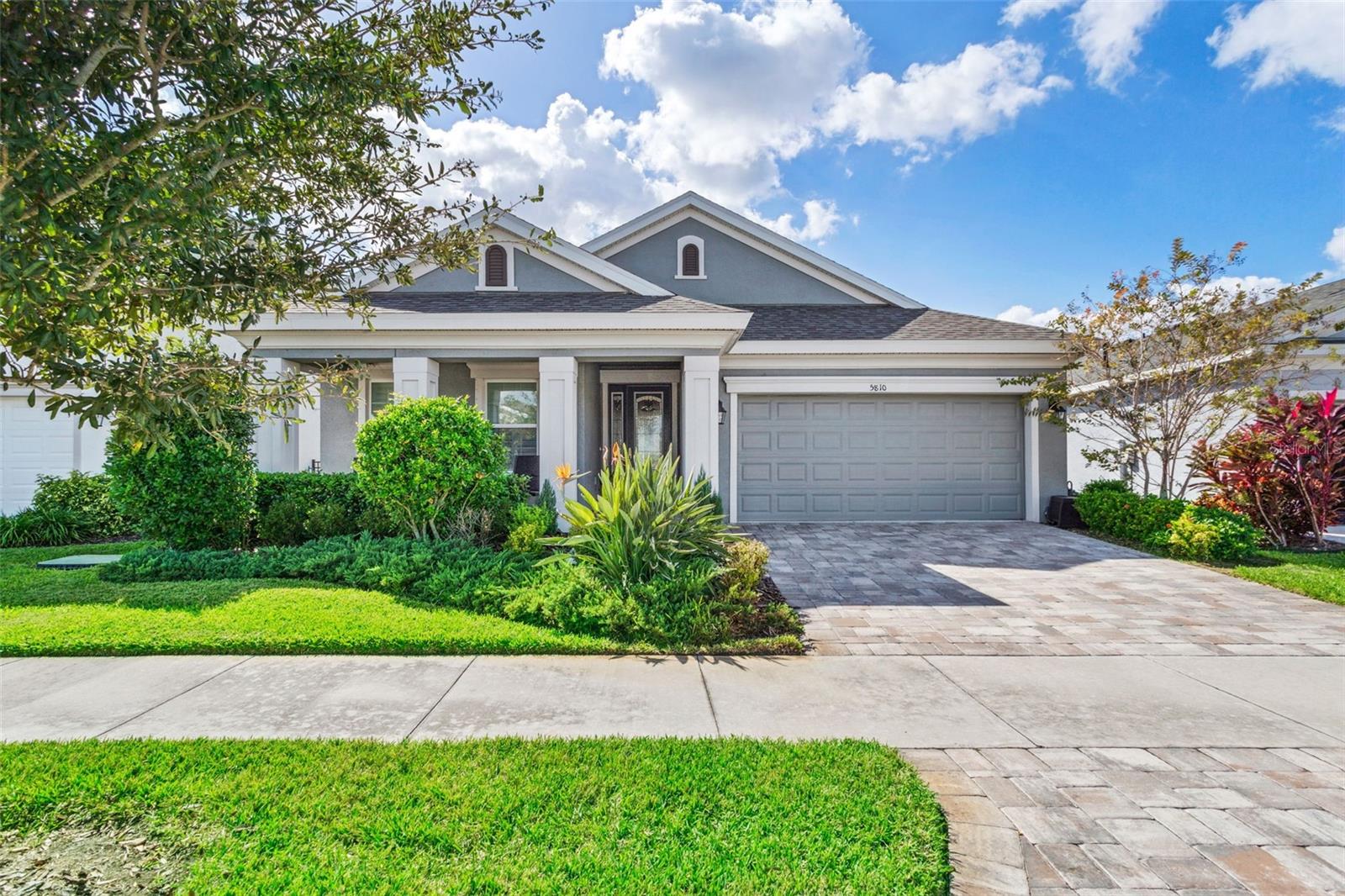 This lovely Waterset home offers 3 bedrooms plus den/office, 2 bathrooms and 2 car garage - all on a beautiful waterfront lot.  Enter through the leaded glass door into the foyer of this modern and elegant home.  Just beyond is the spacious and bright kitchen, dining room and family room combination that is perfect for entertaining.  The family room has sliding doors that open to an extended screened lanai overlooking a sparkling pond with stunning nightly sunset views. The upgraded kitchen is a cook’s dream with 42” cabinetry, quartz counters, island, gas range, stainless steel appliances and walk-in pantry.  The large owner’s suite has two walk-in closets and a luxurious ensuite bath with double sinks, garden tub, walk-in shower and separate water closet. Some of the many decorative upgrades include tile throughout the entire home (including bedrooms), crown molding, plantation shutters, French doors to the den/office, interior laundry room with utility sink, brick paver driveway, hurricane shutters and multiple Energy Star features.  The exterior features a 26x20 screened lanai with covered and open areas for relaxing or entertaining, brick paver decking, and a fabulous outdoor kitchen including gas grill, smoker and pizza oven.  All of this is surrounded by a fenced yard with a serene water view.  Waterset is a resort style community with clubhouses, café, heated pool, fitness center, parks, playgrounds, lake trails, frequent events and more (watersetfl.com for more info). You get all of this along with easy access to schools, shopping, restaurants, beaches and everything Tampa Bay has to offer!