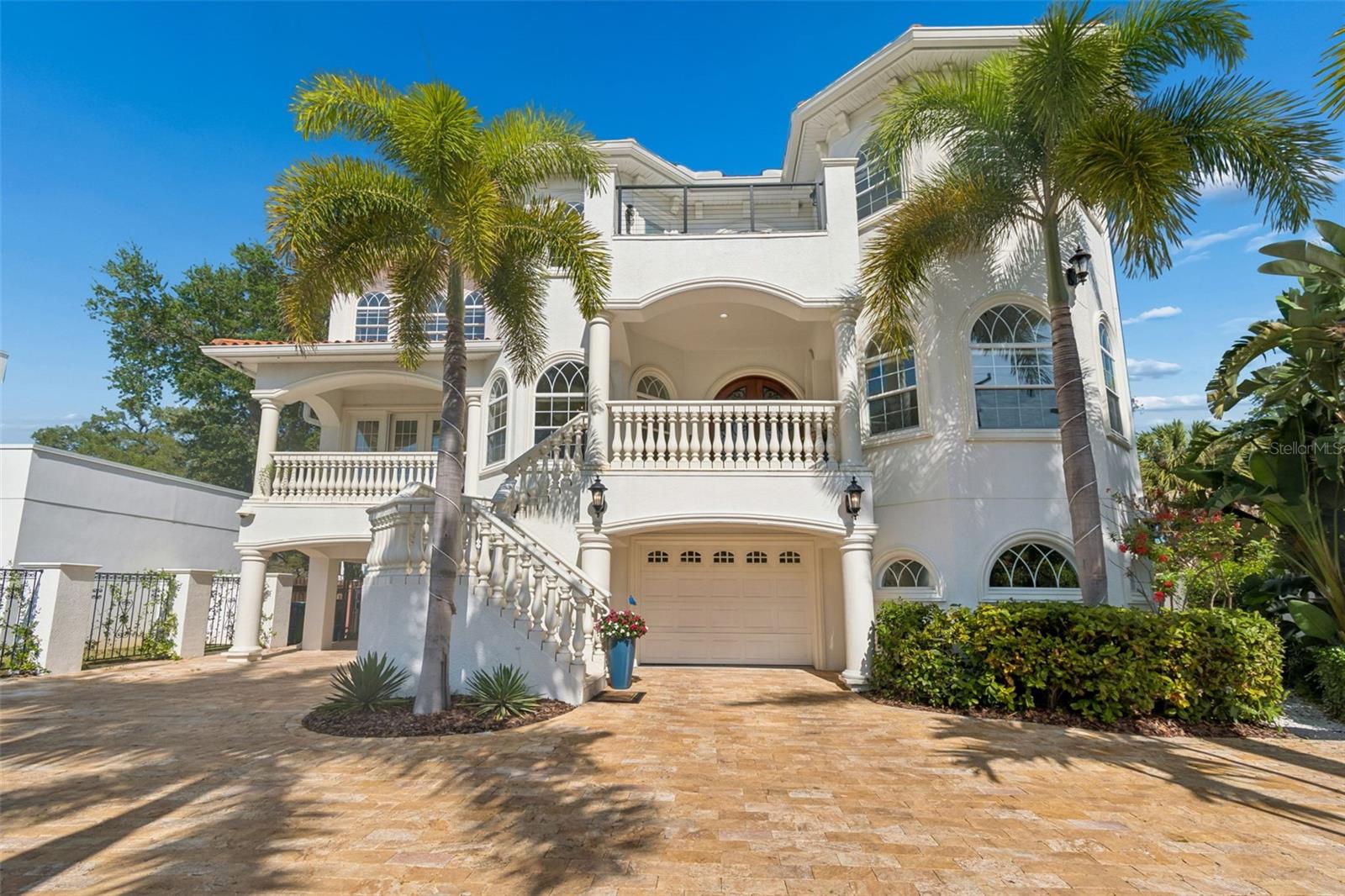 Under contract-accepting backup offers. Positioned along Bayshore Boulevard directly across from Hillsborough Bay, this privately gated Mediterranean estate offers an exceptional blend of grandeur, privacy, and refined craftsmanship. Built in 2010 and encompassing almost 6,000 heated square feet with over 10,000 total square feet, this impressive residence features 6 bedrooms, 5.5 baths, and a private elevator, delivering both scale and sophistication.
A grand arrival begins with a travertine driveway and arched mahogany double doors that open to an elegant two-story foyer, highlighted by a sweeping curved staircase with custom wrought-iron railings. Formal living and dining room flow effortlessly into the expansive family room, showcasing coffered ceilings, a fireplace, and seamless connectivity to the home’s outdoor living spaces.
Designed for both everyday living and entertaining, the gourmet kitchen features custom cabinetry, granite and dolomite countertops, high-end appliances, a wine refrigerator, oversized island with prep sink, and abundant counter space. An enclosed wine cellar is perfectly positioned between the formal spaces and kitchen, enhancing the home’s entertaining appeal.
French doors and pocket sliders create a true indoor-outdoor lifestyle, opening to multiple balconies on both the second and third levels, a stunning front patio with bay views, and a spacious covered rear lanai. The main level also includes a guest suite with full bath, a home theater/media room, and a game room with bar—all with direct access to the resort-style pool and outdoor entertaining areas.
The upper level reveals a luxurious primary retreat featuring wood and marble flooring, a private sitting area with fireplace and balcony overlooking the bay, an oversized custom walk-in closet, and a spa-inspired bath with garden tub, rain shower with dual heads, and dual vanities. Four additional bedrooms include two en-suite suites and a Jack-and-Jill layout, all appointed with custom closets.
Outdoor living is equally impressive, with a travertine pool and spa, expansive paver decking, and a fully covered outdoor kitchen complete with grill, sink, and refrigerator—ideal for year-round entertaining. Additional highlights include a whole-home water filtration system, private gated entry, extensive storage, a six-car driveway, and a four-car garage with a gym space and bonus area.
A short drive to Tampa Yacht Club and MacDill AFB this exceptional Bayshore residence offers the ultimate combination of luxury, location, and lifestyle.