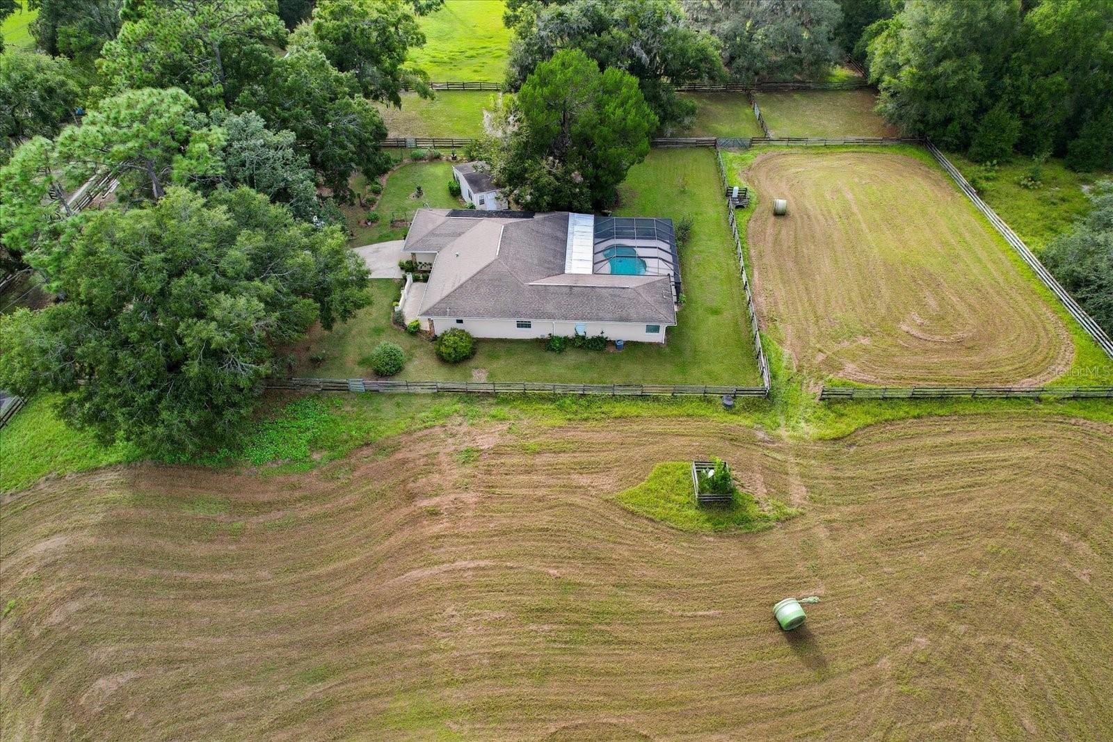 COMMERCIAL & RESIDENTIAL - Best of Both Worlds! This property is a beautiful 14+ acre Ocala horse farm — but so what!? There are lots of beautiful horse farms around Ocala; it is, after all, the Horse Capital of the World. What sets this one apart is location and potential. Situated within a mile of the Florida Horse Park and the Trailhead, this farm offers potential direct access to the Florida Trail System, easy access to I-75, and a prime setting on 475A — perfect for a quick 20-minute drive to the World Equestrian Center, downtown Ocala, or The Villages. What makes it unique, the property is Zoned A1 with a Future Land Use designation of Employment Activity Center / Equine Commercial Support District — a rare opportunity for those seeking a private equestrian retreat with strong long-term commercial investment potential. Perfect for the equestrian lifestyle today, with exciting potential for tomorrow! The site allows for multiple opportunities including commercial, manufacturing, multi-unit residential, and more. Property features include a grassed arena of dressage size plus five paddocks, with room to add additional turnout areas. A 60 ft x 30 ft pole barn includes five stalls, water, feed, and tractor storage. Current income is generated through horse boarding. There is also an additional two-stall stable with automatic waterers and electric, along with an extensive concrete area ideal for feed storage and wash rack. The main home features a split, open floor plan with two master suites—one with a walk-in shower and jacuzzi bath, the other with a walk-in shower. Both have walk-in closets. The third bedroom is served by a full bath with an over-tub shower. The kitchen offers stainless appliances, wood cabinetry, and granite countertops, and opens to a spacious great room/dining area that leads through disappearing sliders to a lovely covered lanai and a screened, solar-heated 28 ft long, 10,300-gallon kidney-shaped pool with salt chlorinator and waterfall. Additional highlights include dual HVAC systems, dual hot water systems, and two wells. The property also includes a 2004 recently renovated 3/1 mobile home (The Lone Pine Lodge), currently leased for additional income, a 30 ft x 12 ft office adjacent to the main house with full utilities, and an extra storage shed. Surrounded by A1 properties to the north up to the Horse Park (none of which have future commercial zoning) and positioned for commercial growth to the south toward CR 484, this property truly sits in the sweet spot for both immediate enjoyment and future development. Definitely the best of both worlds!