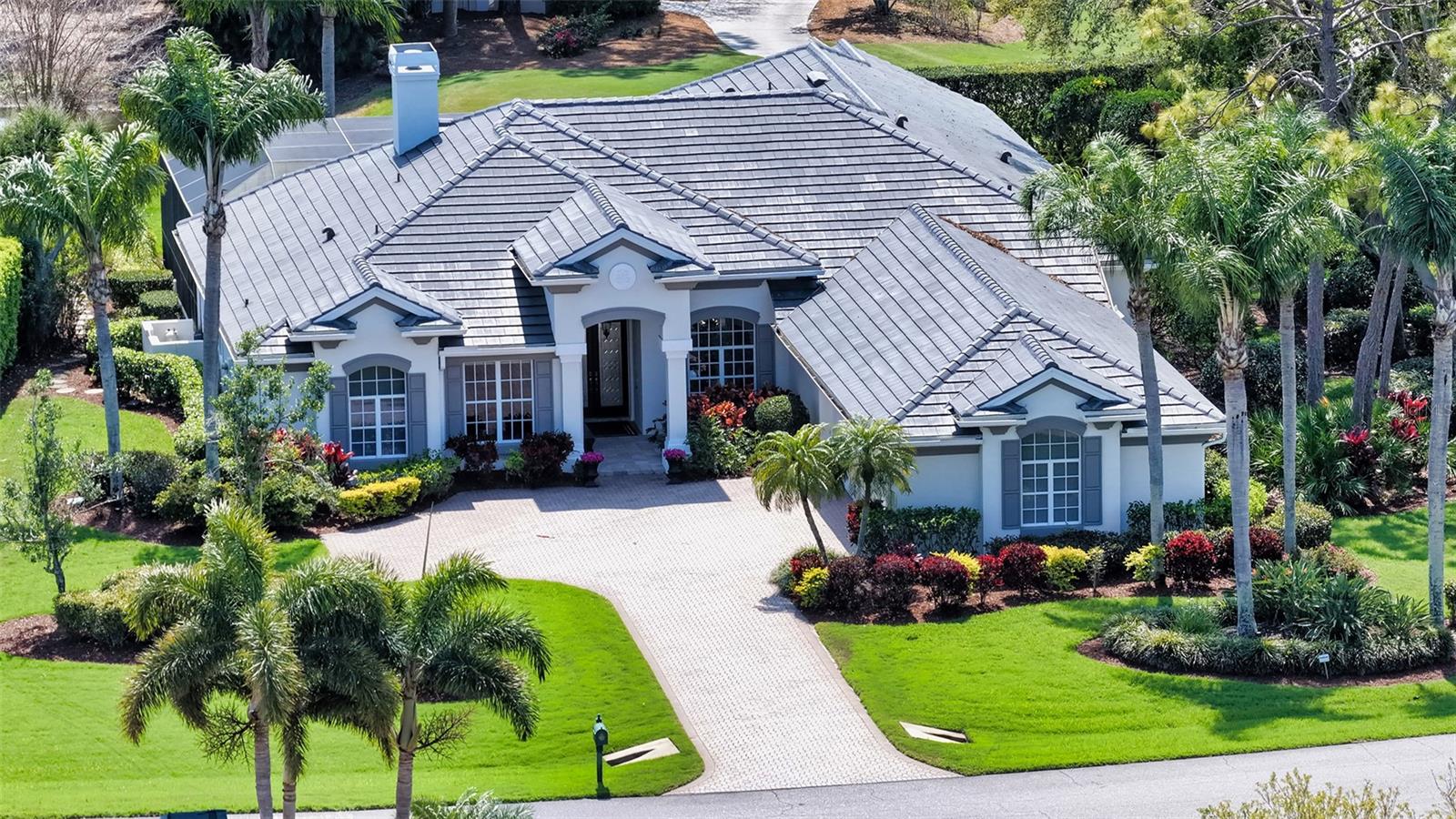 Beautifully updated and carefully maintained, this Rutenberg-designed home is idyllically situated on a half-acre corner lot surrounded by beautiful landscaping with views of the lake and the 14th Fairway of the Heron Course. This 4 bedroom residence has 4 full baths, 1 half bath, a formal living room with pool views, a separate formal dining room, and an open gourmet kitchen with gas cooktop, stainless appliances, two wall ovens, a breakfast bar, an adjoining dining area and two pantries.  The kitchen opens to an expansive family room overlooking the pool. The spacious master suite features a large luxury bath, two large his-and-hers closets and a lovely sitting area overlooking the pool. All three additional bedrooms are en suite. A dedicated office with built ins and a versatile bonus room/game room adds valuable flexibility for a wide variety of lifestyles. The large and lovely lanai includes an outdoor grill and bar, covered seating, awnings, and a freeform pool and spa overlooking the water and golf course. With a four car garage, abundant storage and numerous updates, including a new roof installed in December 2024 (with warranty), a new pool heater installed in 2024, new central air conditioning (2 units, 2 zones) in 2022, freshly painted interior and exterior, this home is the perfect choice for those who want to live in comfort and luxury.  A complete list of updates is available.  The mandatory Membership to The Oaks Club will provide everything for living a country club lifestyle; two championship golf courses, tennis and pickleball courts, a regulation croquet lawn, state-of-the-art wellness center and a wide array of dining and social options.