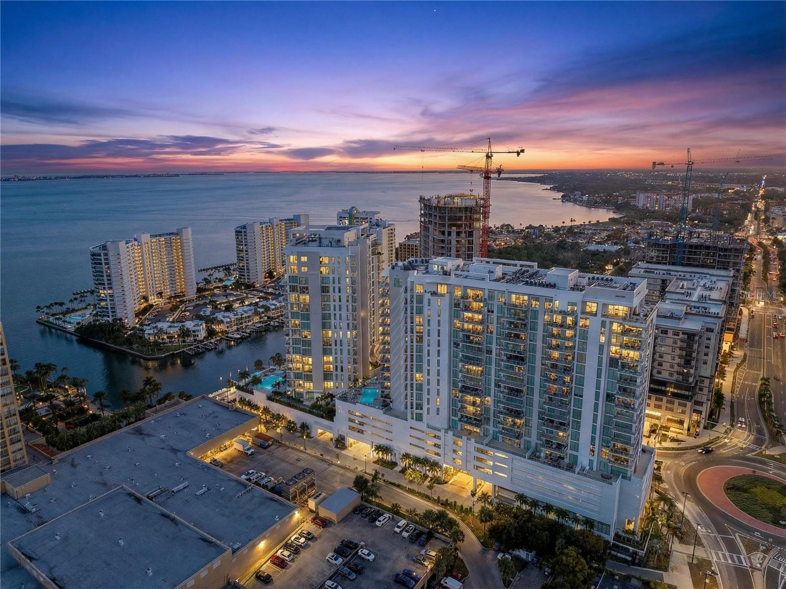 Welcome to elevated living in The Quay Sarasota, where downtown energy meets coastal calm. Located on the 18th floor of BAYSO, this beautifully designed residence offers peek a boo views of Sarasota Bay, Downtown Sarasota, and Marina Jack, creating a light filled retreat above the city.

With nearly 1,600 square feet of thoughtfully planned living space, the residence features two spacious ensuite bedrooms, a versatile den, and two and a half bathrooms. The layout is ideal for full time living or a stylish seasonal escape that comes FULLY FURNISHED. Floor to ceiling glass opens to an expansive terrace that enhances the indoor outdoor flow and provides the perfect setting for sunset evenings.

This desirable BAYSO floor plan includes two premium parking spaces, a rare and valuable offering. The den and laundry room are positioned away from the main living area for added functionality and privacy. Designer finishes and developer upgrades include modern shades, quartz countertops with subtle gold and gray accents, an induction cooktop, double oven, Italkraft European cabinetry with coastal inspired contrast, and porcelain tile flooring throughout. The space offers a wonderful opportunity to add your own personal touches and truly make it your own.

Beyond the residence, enjoy a vibrant waterfront lifestyle just steps from the bay. Boutique shopping, dining, boating, and wellness experiences await, including yoga and community events at The Bay Sarasota. BAYSO is a dog friendly community featuring a dedicated dog park on the fifth level and a resort style pool deck with serene bay views.

This is your opportunity to be part of Sarasota’s newest waterfront district and enjoy a lifestyle that blends sophistication, comfort, and everyday ease.