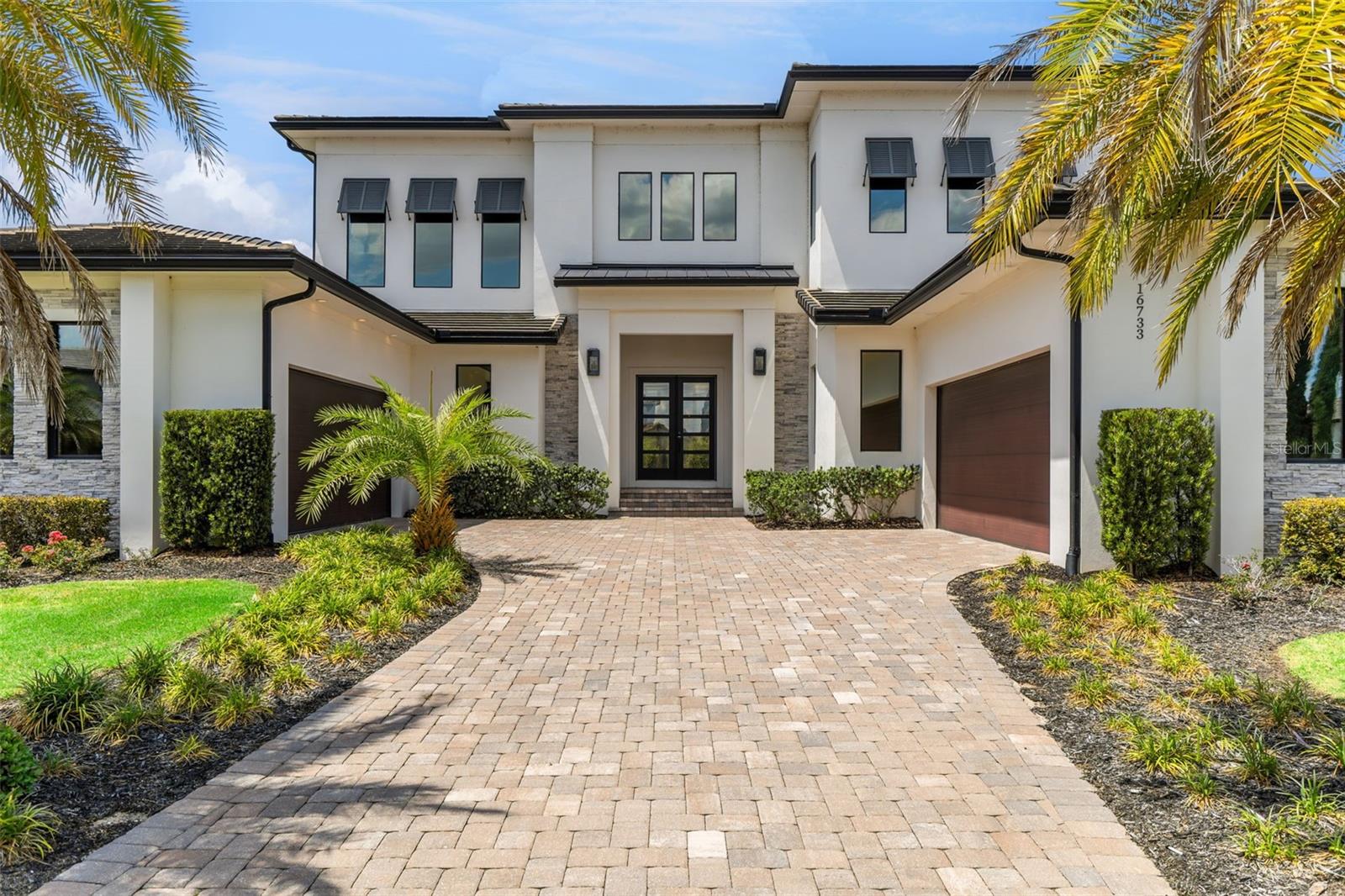 Discover timeless elegance and modern luxury in this custom-built estate located within the private guard-gated community of Bella Collina. Delivered to the current owners in 2019 and crafted with exceptional quality and attention to detail, this stunning residence is positioned on a spacious homesite offering added privacy with no rear neighbor and no neighboring home on one side. Surrounded by nearly 2,000 acres of rolling hills, pristine lakes, and the renowned Club at Bella Collina, the home offers an unmatched luxury lifestyle in Central Florida.

Follow the stone paver driveway to the grand entrance framed by dual two-car garages and modern double doors that open into transitional interiors filled with natural light. The expansive great room flows effortlessly through the living and dining spaces, highlighted by designer chandeliers, custom floating ceilings, beautiful flooring, and striking stone accents. At the heart of the home is a chef’s kitchen featuring a dramatic quartz waterfall island with apron sink, Bosch dishwasher, Wolf double ovens and gas range, Sub-Zero refrigerator, wine refrigerator, solid 2-inch quartz countertops and backsplash, and a spacious walk-in pantry. A stunning glass and stone wine room creates an impressive architectural focal point perfect for entertaining.

Designed for seamless indoor-outdoor living, the spacious family room opens through expansive sliding glass doors to multiple covered lanai spaces overlooking the fenced backyard and resort-style saltwater pool. The outdoor living area is complete with a summer kitchen and custom phantom screens for year-round enjoyment. The first-floor primary suite is a private retreat featuring a freestanding soaking tub, oversized walk-in closet, floating quartz vanities, and a spa-inspired bath designed to impress. An additional guest suite is conveniently located on the main level, while upstairs offers a large loft overlooking the great room below, two additional ensuite bedrooms, and generous storage space.