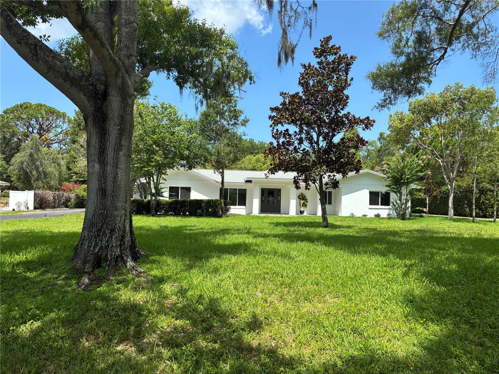 Virtually Staged. Magnificent, upscale, contemporary split-plan pool home.  Craftsmanship is evident throughout this distinctive Level 3 remodeled home.  New roof, hurricane rated windows and doors, HVAC, electric, plumbing, irrigation system with private well.  Features 4 bedrooms, 3 baths, 3 car garage, with a large panoramic porch on fenced nearly one-acre landscaped lot.  The new kitchen boasts large quartz island, quartz countertops, stainless steel appliances with gas range, soft-closed hardwood cabinets in kitchen and baths (w/pullout drawers). Backyard features a beautiful 32X16 9' deep pool with fountains and tanning shelf.  Brick pavers high-light the expansive patio with fans and lighting-perfect for dining, lounging and entertaining.  Fenced beautiful, landscaped backyard with room for tennis, pickleball, playground and garden.  This picturesque home is in a private neighborhood in an excellent Clearwater location on a quiet street in a non-HOA neighborhood.  Minutes from world-renowned Clearwater Beach, Eagle Lake Park, top schools, Morton Plant Hospital, Shopping, Dining and major thoroughfares.  Contact us today to schedule a private showing of this Clearwater jewel.