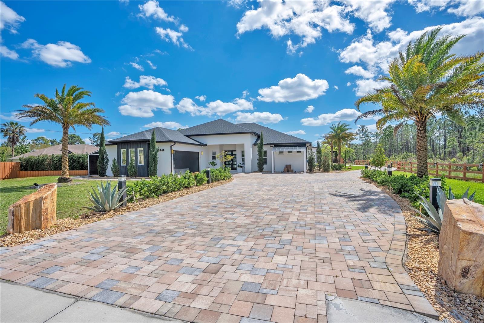 Custom-built 6-bedroom, 5-bathroom estate on 1.24 private acres in Cape Orlando Estates, Orlando, FL 32833 — completed in 2022, no HOA, no CDD. A climate-controlled 12-car garage showroom, an open-air high-clearance RV and repair structure, a fully independent ADU with its own address, three separate laundry areas, a private side garden, and a resort-style courtyard with gas summer kitchen make this one of the most versatile luxury estates in the Central Florida market.
GARAGE & VEHICLE INFRASTRUCTURE: Ten vehicles in a detached climate-controlled showroom with soaring ceilings, double insulation, air conditioning, industrial ceiling fan, polished white porcelain floors, a full bathroom, dedicated laundry, and a private office suite on the upper level — ideal for a luxury, exotic, or classic car collection. Two additional attached garage spaces serve the main residence with direct entry. A separate open-air high-clearance structure accommodates motorhomes, RVs, and oversized vehicles, and functions as a covered automotive repair workspace. A dedicated professional car wash station with electric pressure washer and commercial vacuum system completes the on-site vehicle infrastructure.
MAIN RESIDENCE — 4 BED / 3 BATH: Open-concept floor plan with high ceilings, hardwood floors, decorative wood beams, stone accent wall with fireplace, and natural light throughout. Kitchen features a large center island, generous cabinetry, and GE Café white appliances. Primary suite includes a stone accent wall, walk-in shower, plantation wood shutters with blackout blinds, and a custom Container Store closet with integrated lighting. The main residence opens to a private enclosed side garden exclusive to the primary home.
ADU — 2 BED / 1 BATH, OWN ADDRESS: Fully independent accessory dwelling unit with private entrance, hardwood floors, GE Café appliances, porcelain sink, plantation shutters with blackout blinds, and dedicated laundry. Ideal for multigenerational living or uses permitted by local regulations. Main home, ADU, and garage each operate with fully separate laundry areas.
OUTDOOR & GROUNDS: Palm-lined interior courtyard with a covered gas summer kitchen — porcelain countertops, dual refrigerators, ice machine, built-in grill, two stove burners, prep sink, and surround speakers under a high-quality insulated roof. Beyond the structures, a large rear garden preserves expansive open green space across the full 1.24-acre lot. An on-site enclosed storage container provides secure storage for equipment, tools, or inventory. Paver driveways wrap front and rear. Exotic palms, specimen plantings, decorative stone, two decorative fountains, full roofline architectural lighting, and a comprehensive security camera system monitoring all structures.
LOCATION: Cape Orlando Estates — 20 minutes from Lake Nona Medical City, 25 minutes from Orlando International Airport, 40 minutes from Cocoa Beach and the Atlantic Coast, and minutes from SR-528 (Beachline Expressway), Waterford Lakes Town Center, and major Central Florida employment and healthcare centers. A climate-controlled 12-car showroom, open-air RV and repair structure, separate-address ADU, private side garden, gas summer kitchen, three laundry areas, enclosed storage container, expansive rear grounds, and 1.24 acres — zero HOA, zero CDD. If you're done asking permission and ready to own something that truly reflects the life you've built, contact us today to schedule your private tour.