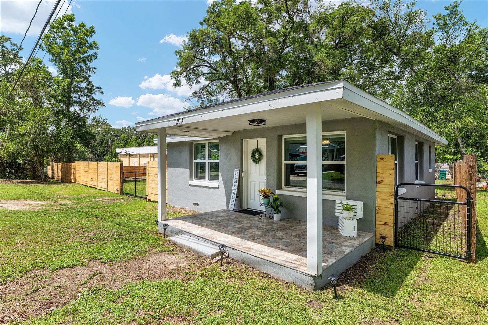 Set on an expansive nearly quarter-acre corner parcel framed by new fencing and wide open skies, this charming midcentury cottage offers a rare sense of serenity that is increasingly difficult to find. Mature trees, generous outdoor space, and the quiet rhythm of a slower pace create a setting that feels grounded, inviting, and full of possibility. Whether envisioned as a first home, an investment opportunity, or a place to simplify and reconnect, the property carries a warmth that feels both approachable and enduring. Built in 1955, the home embraces the enduring appeal of classic architecture paired with practical, thoughtful updates that support modern living. Inside,the living areas balance intimacy with functionality, offering an atmosphere that feels collected over time rather than manufactured. Every corner reflects the kind of character that gives smaller homes their lasting emotional appeal. The kitchen and adjoining living spaces create an effortless cadence for daily life, while the 2 bedroom layout offers flexibility for guests, a home office, creative space, or long term rental potential. The overall footprint lives intentionally, prioritizing comfort, simplicity, and connection over excess. Recent improvements, including a newer roof and HVAC system installed in 2021, add meaningful value and peace of mind while preserving the home’s original charm and authenticity. Outside, the oversized quarter acre lot becomes an extension of the living experience itself, offering room to garden, entertain, expand, store recreational equipment, or simply enjoy the luxury of open space beneath the Florida sky. The newly installed front fence adds both visual character and functionality, framing the property with a welcoming sense of definition while enhancing privacy and curb appeal. As a corner lot, the setting feels especially open and expansive, with a presence that immediately stands apart from neighboring properties.Two off-street parking spaces provide everyday convenience. Cozy in size yet expansive in feeling, this is a property defined not by excess, but by opportunity, character, and the enduring appeal of land and simplicity. The result is a home with soul, offering the kind of flexibility and authenticity that continues to resonate in today’s market.